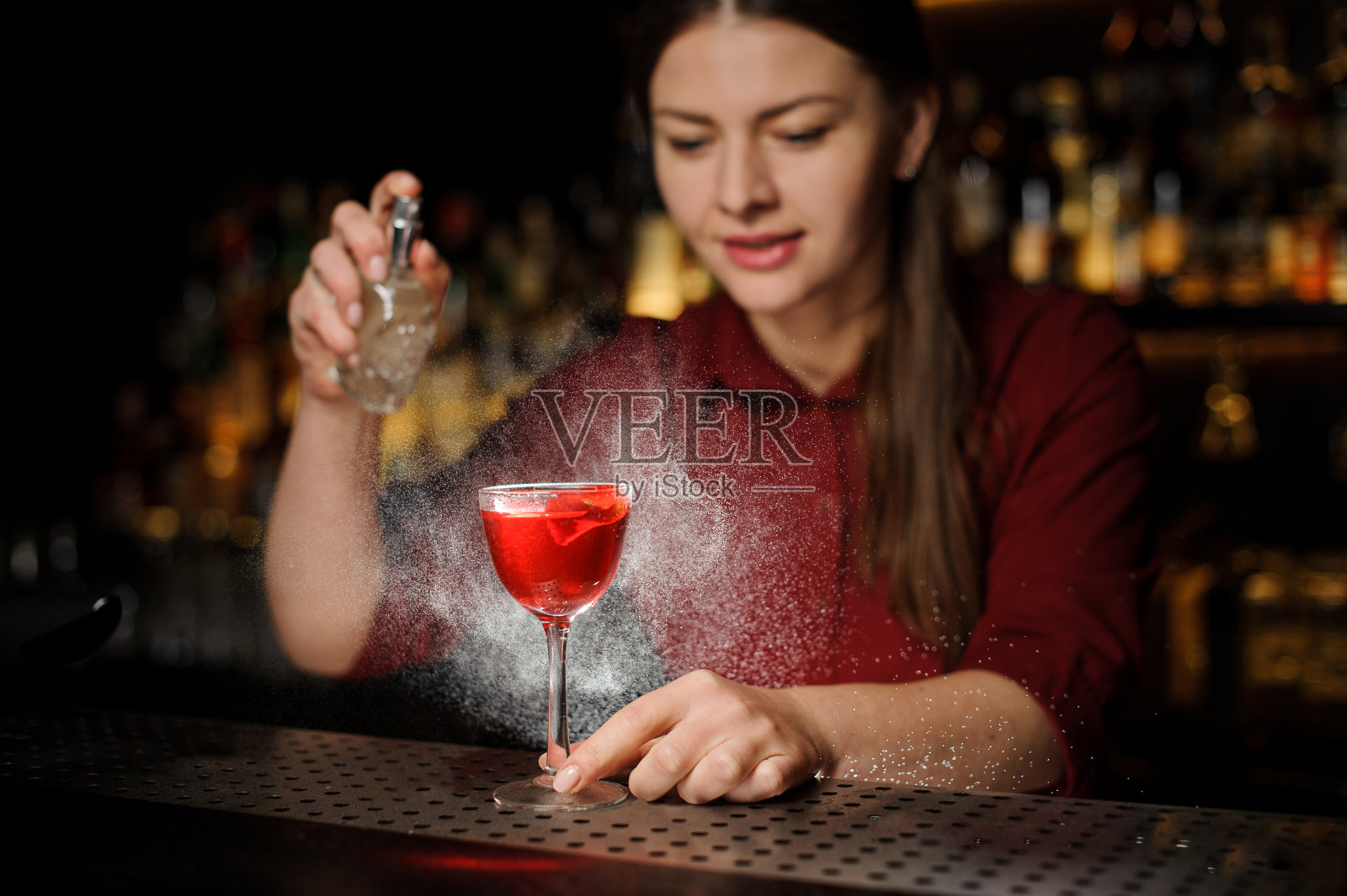 酒吧女招待在酒精鸡尾酒中加入了泥炭威士忌照片摄影图片