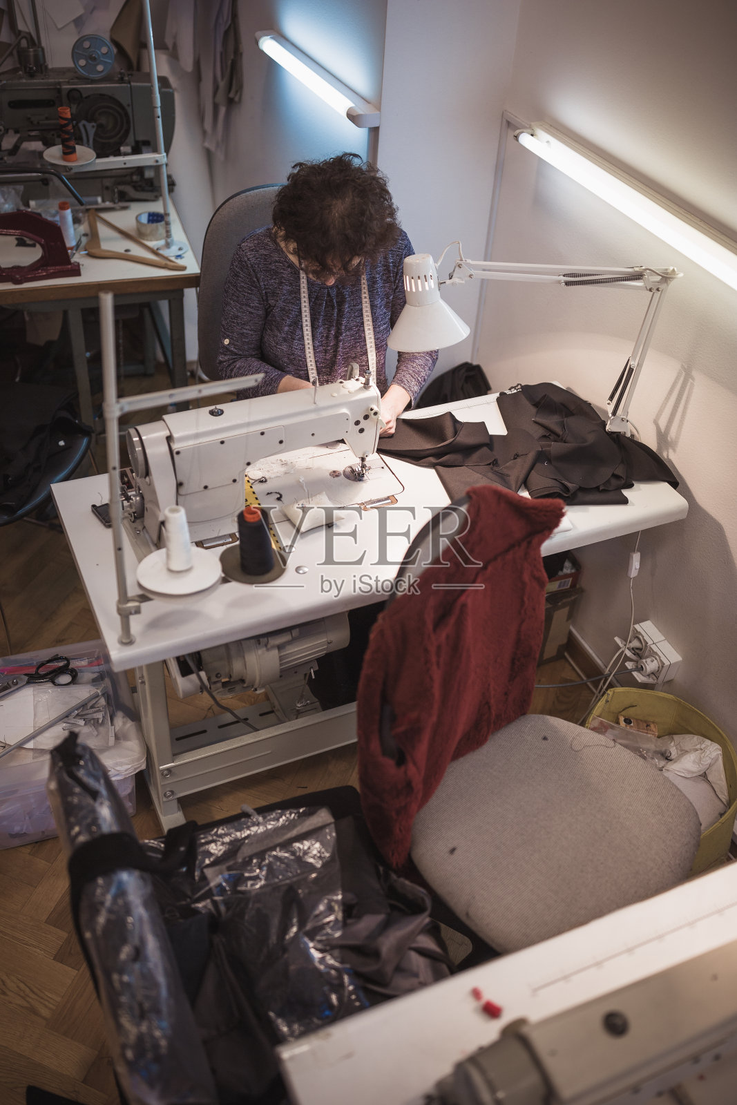 女裁缝用缝纫机。照片摄影图片