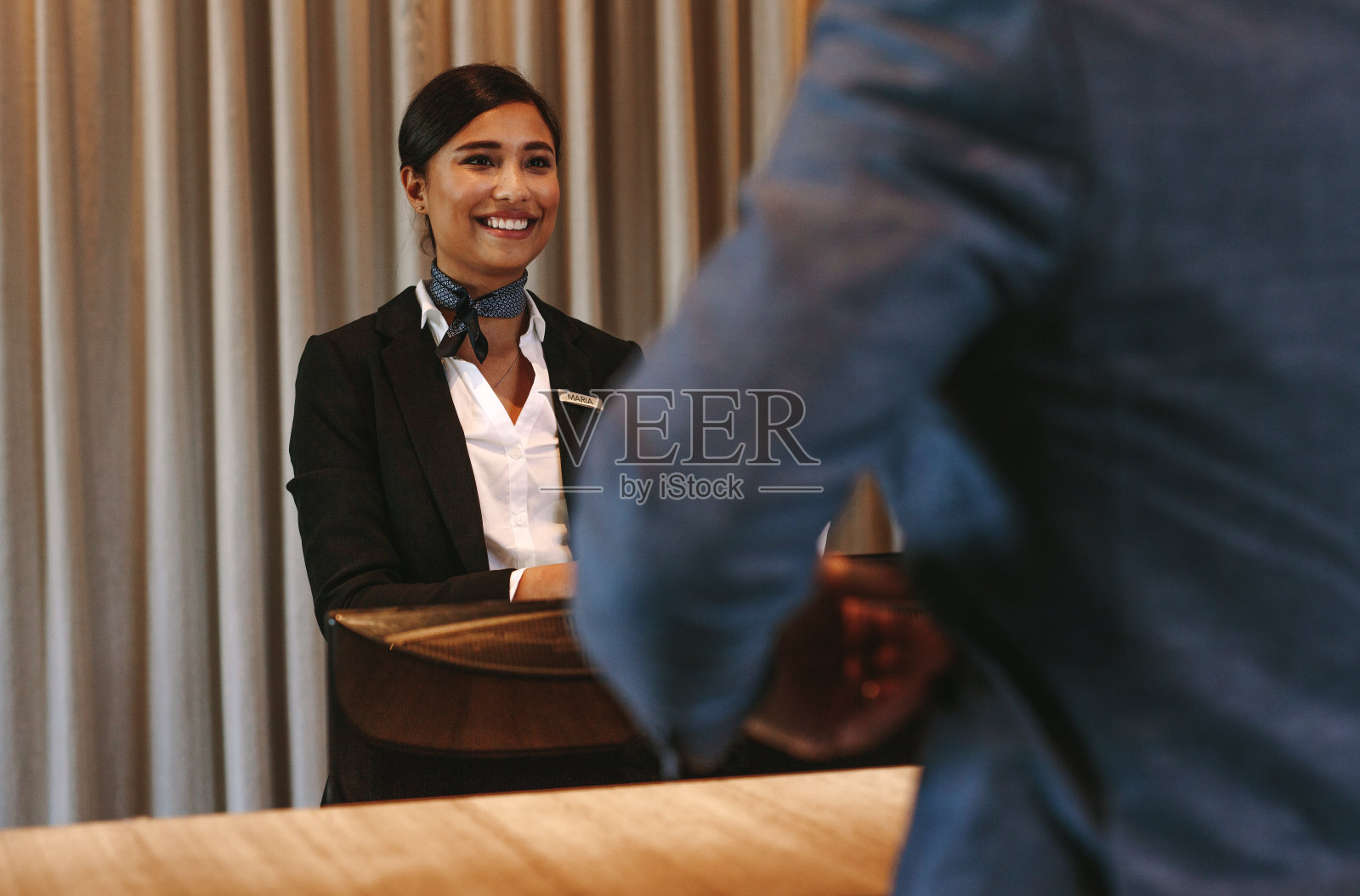 酒店接待员微笑接待入住柜台的客人照片摄影图片