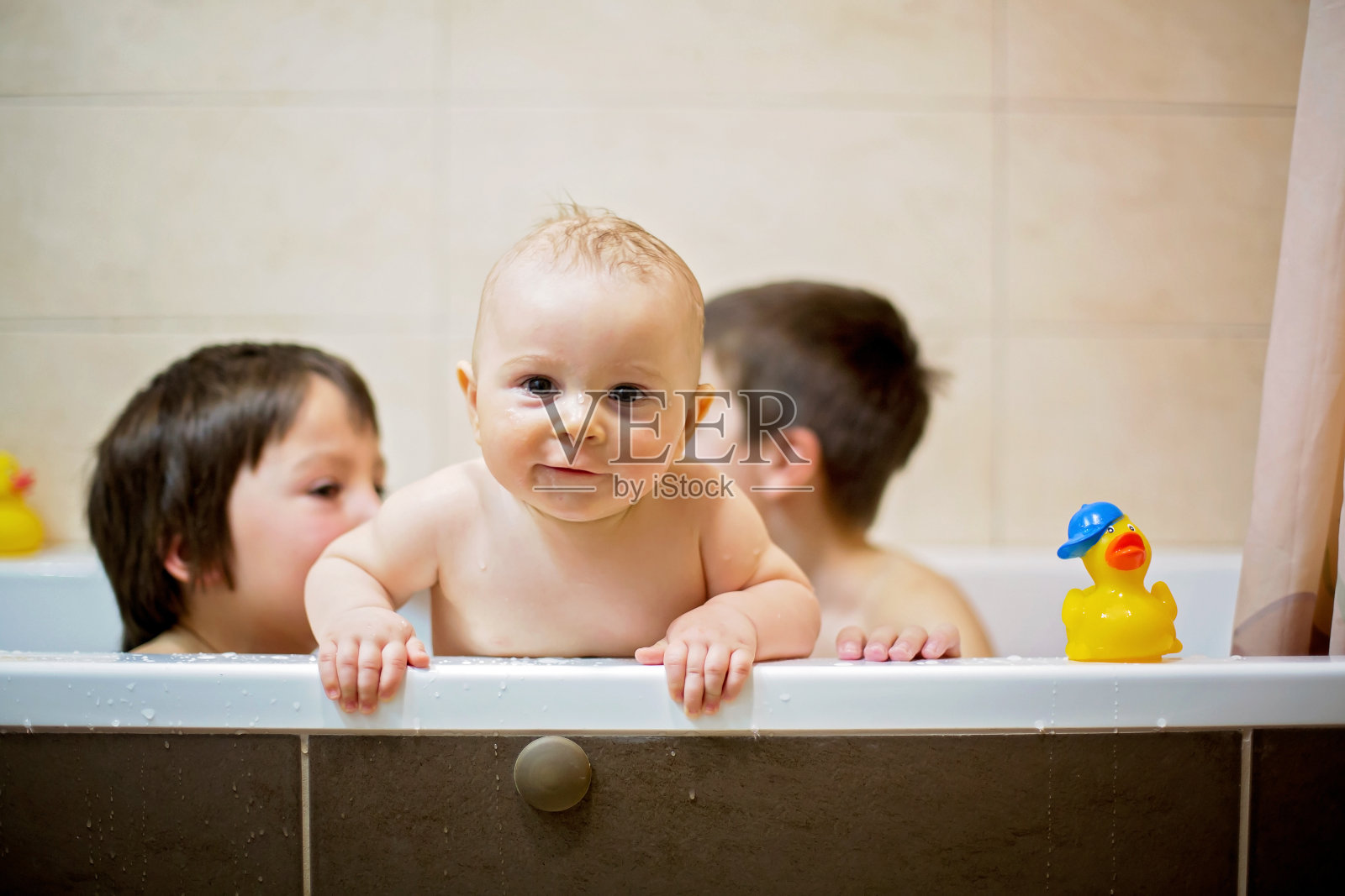 小男孩，在浴缸里玩橡皮鸭照片摄影图片