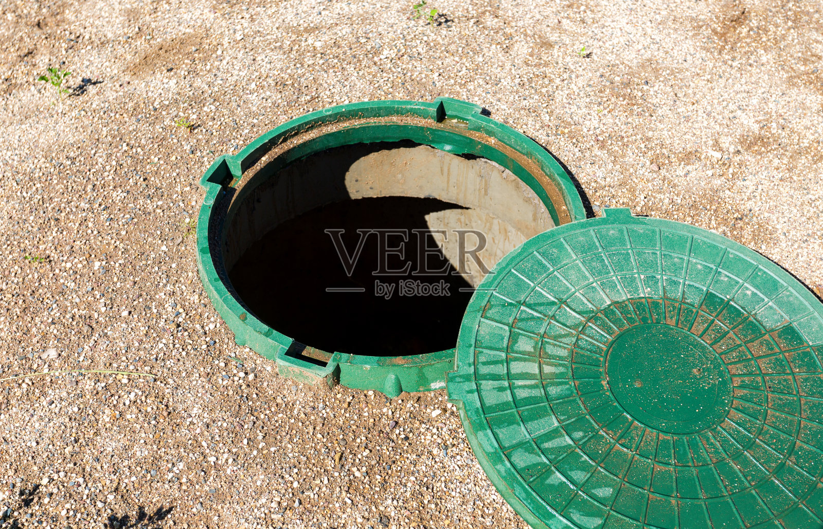 开敞的乡村化粪池污水沙井，盖上绿色塑胶盖照片摄影图片