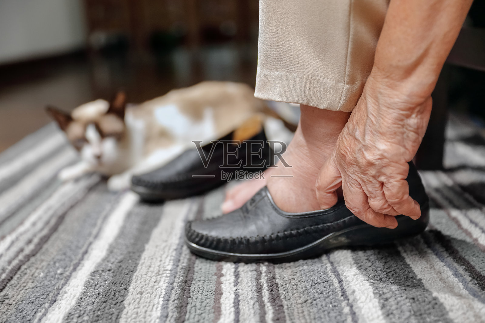 老妇人正在穿鞋，脚肿了照片摄影图片