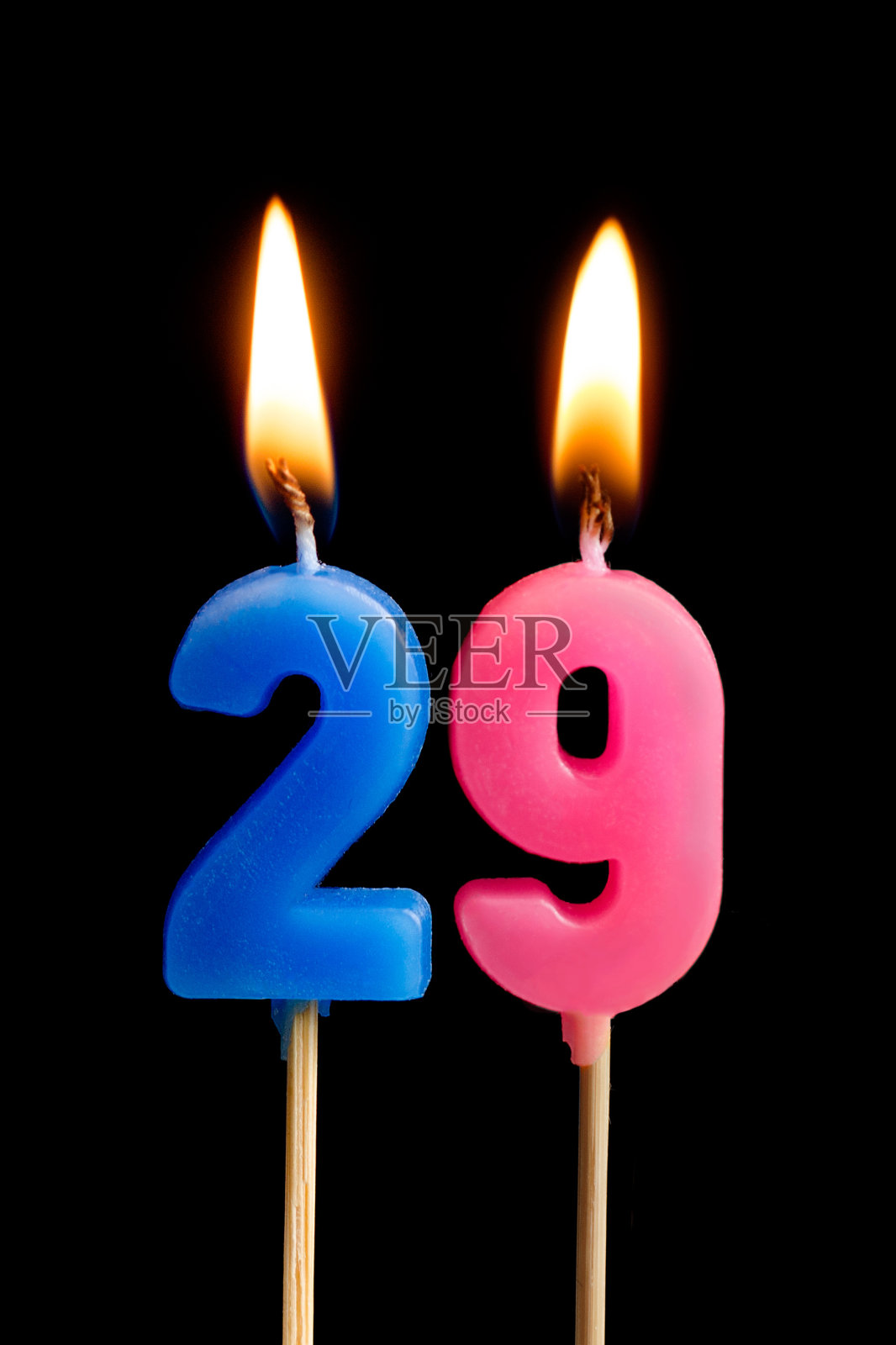 燃烧的蜡烛29 29(数字，日期)的形式为蛋糕孤立在黑色的背景。庆祝生日、周年纪念、重要日期、节日、餐桌摆设的概念照片摄影图片