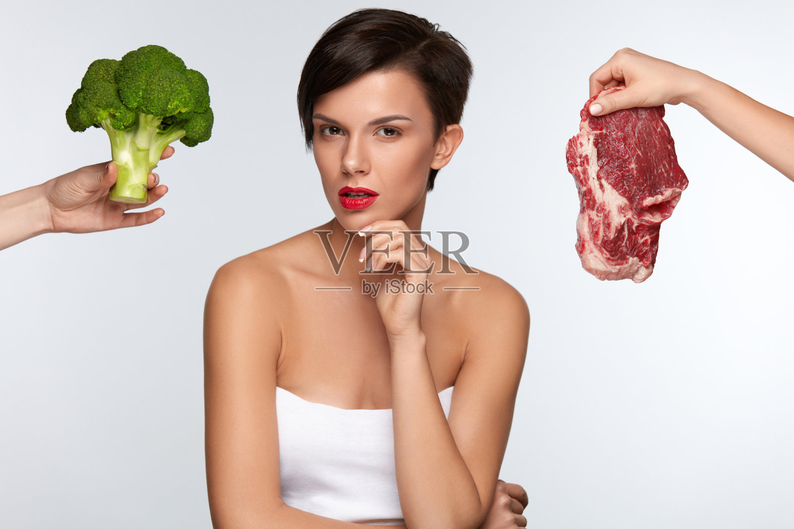 健康美丽的女人在肉和西兰花之间选择照片摄影图片