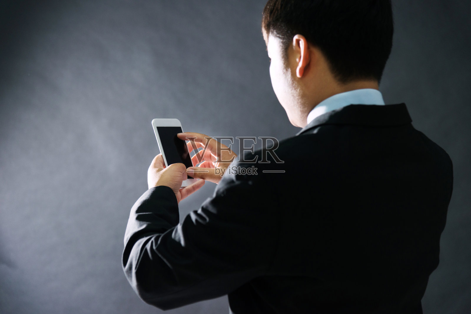 商人在黑色背景下使用手机照片摄影图片