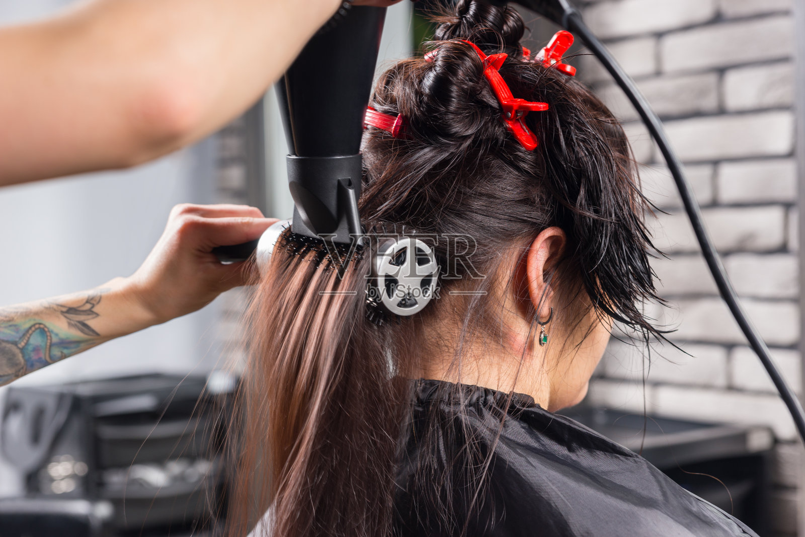 近距离的黑发女子有湿头发梳理和干燥的发型师使用手持吹风机照片摄影图片