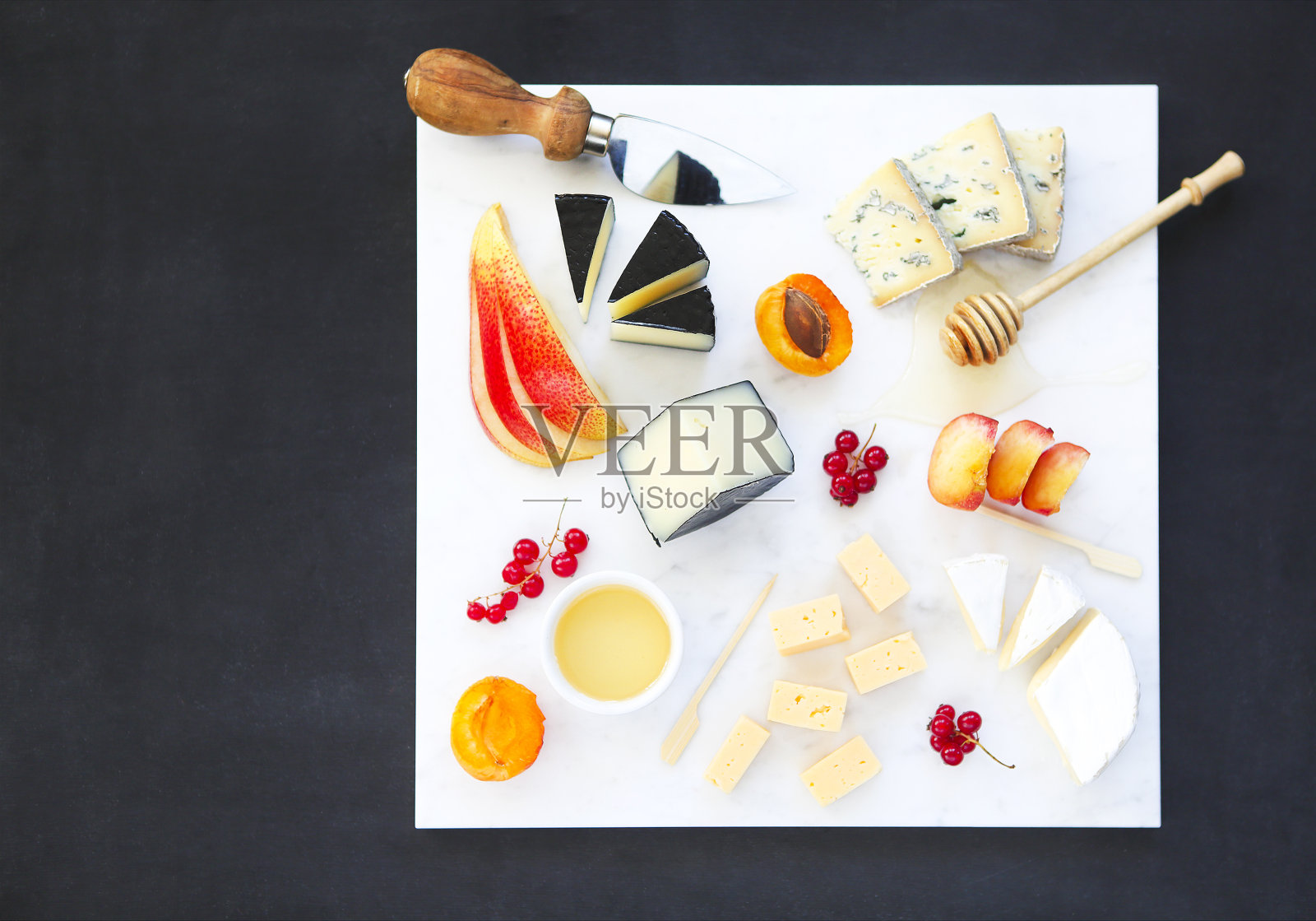 奶酪、蜂蜜和水果。板开胃小菜点心照片摄影图片