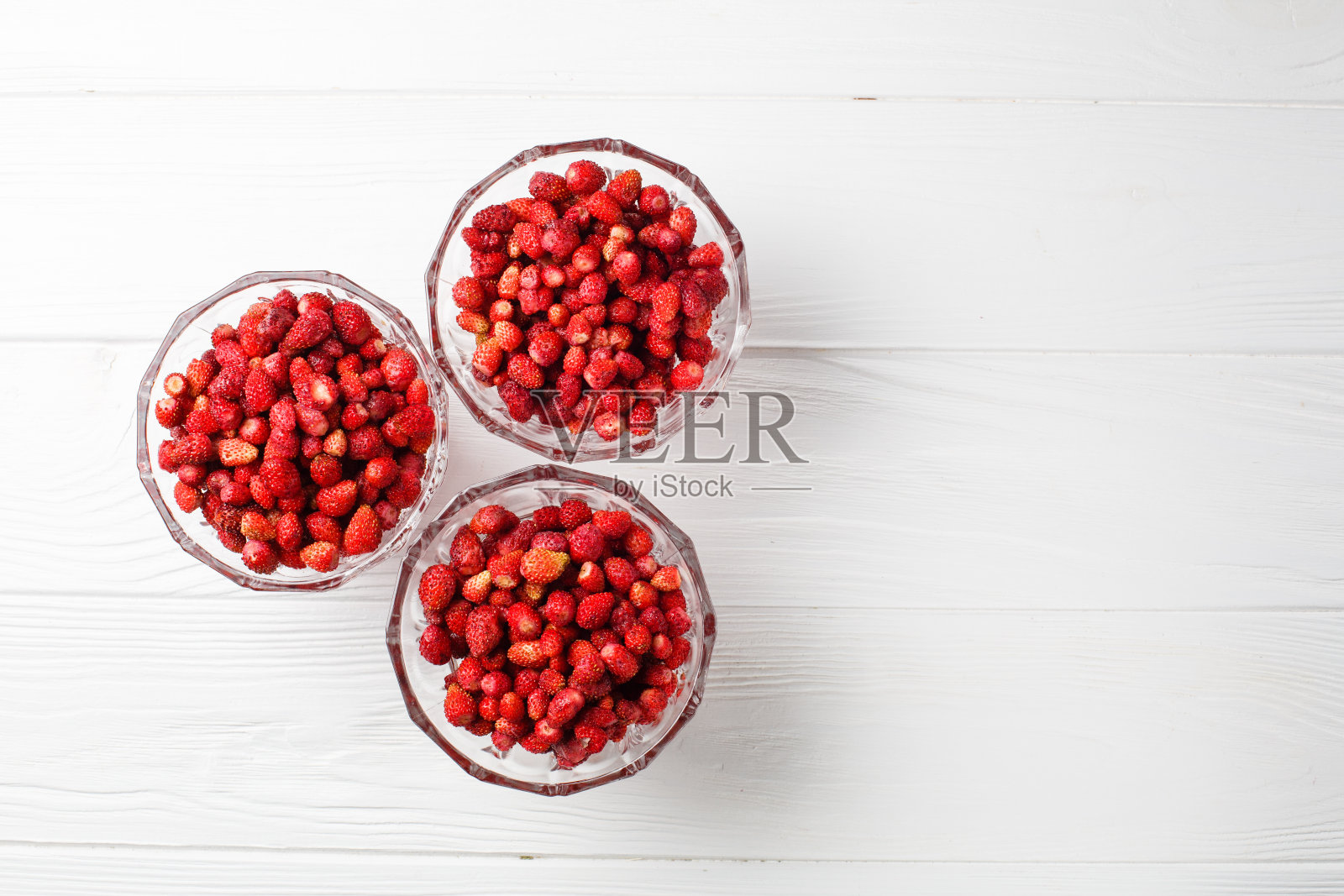 白色背景的玻璃盘子里的新鲜草莓。自由空间。平躺照片摄影图片