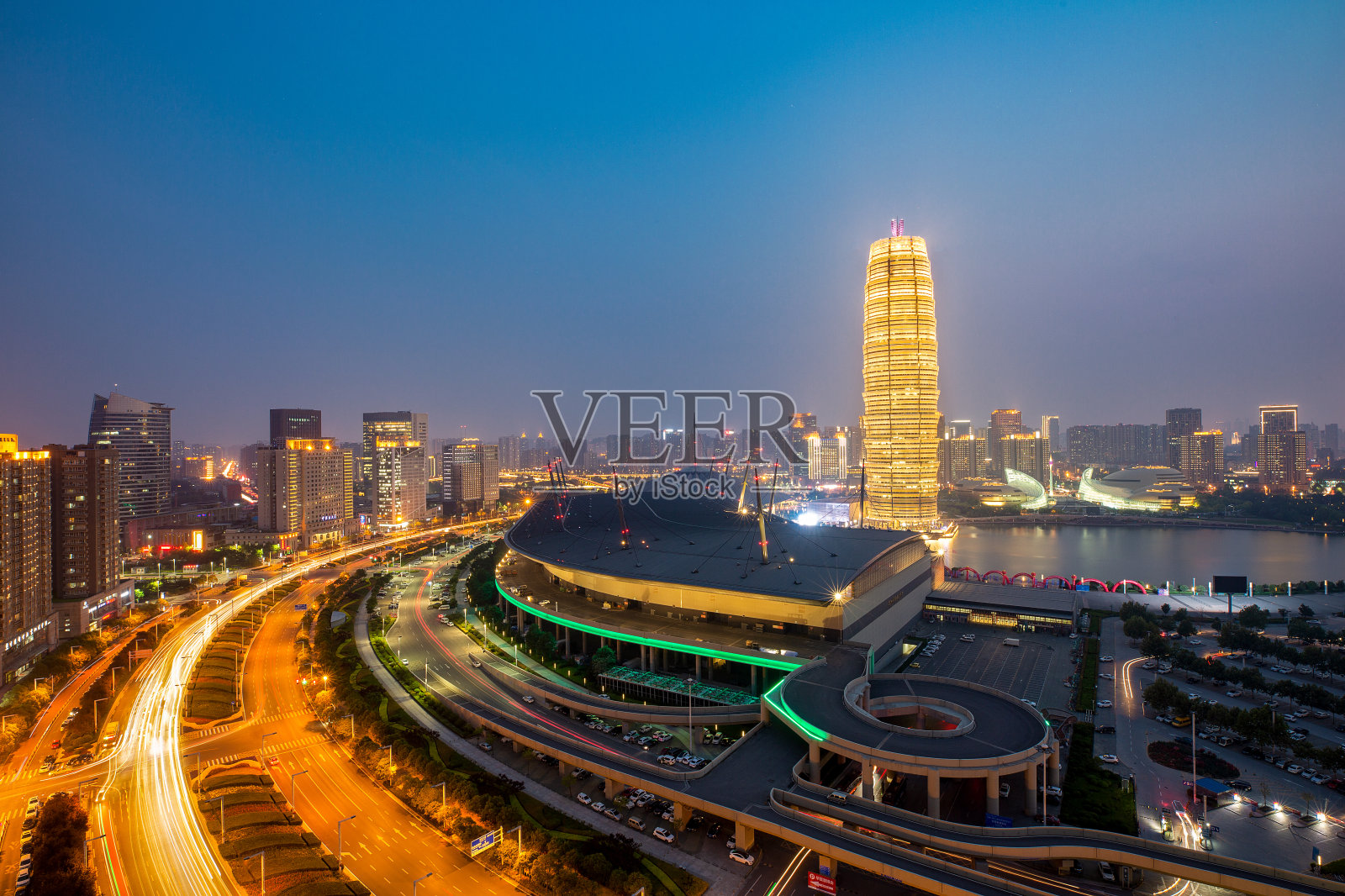 环形道路被湖边的摩天大楼包围，夕阳下的城市天际线。郑州,中国照片摄影图片