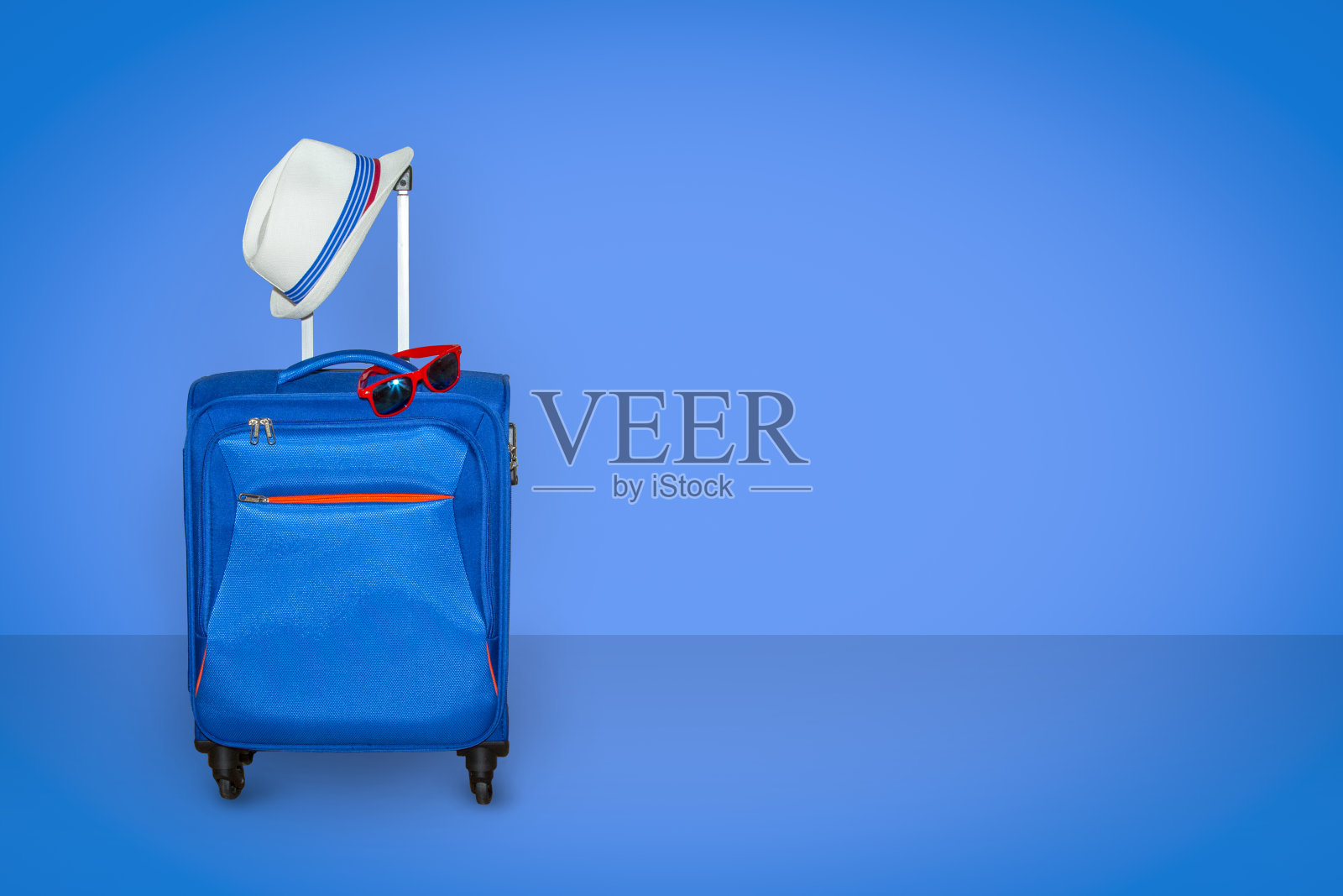 蓝色行李箱，浅蓝色背景，时尚太阳镜，夏日度假旅游理念，自由空间，复制空间照片摄影图片