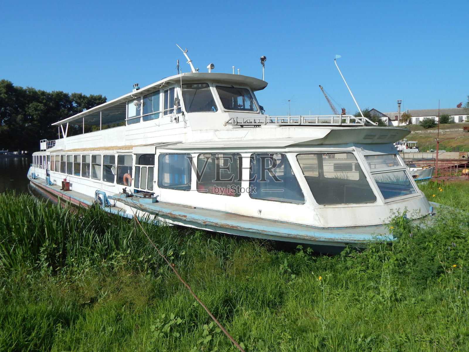 供乘客乘坐的河上有轨电车客船靠近河岸。河上游船的照片。照片摄影图片