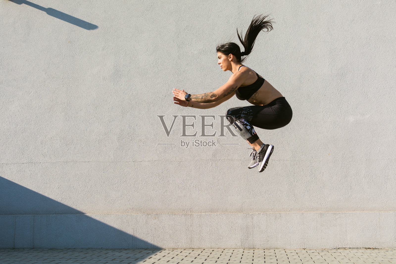 肌肉发达的年轻女子在户外跳跃和奔跑照片摄影图片
