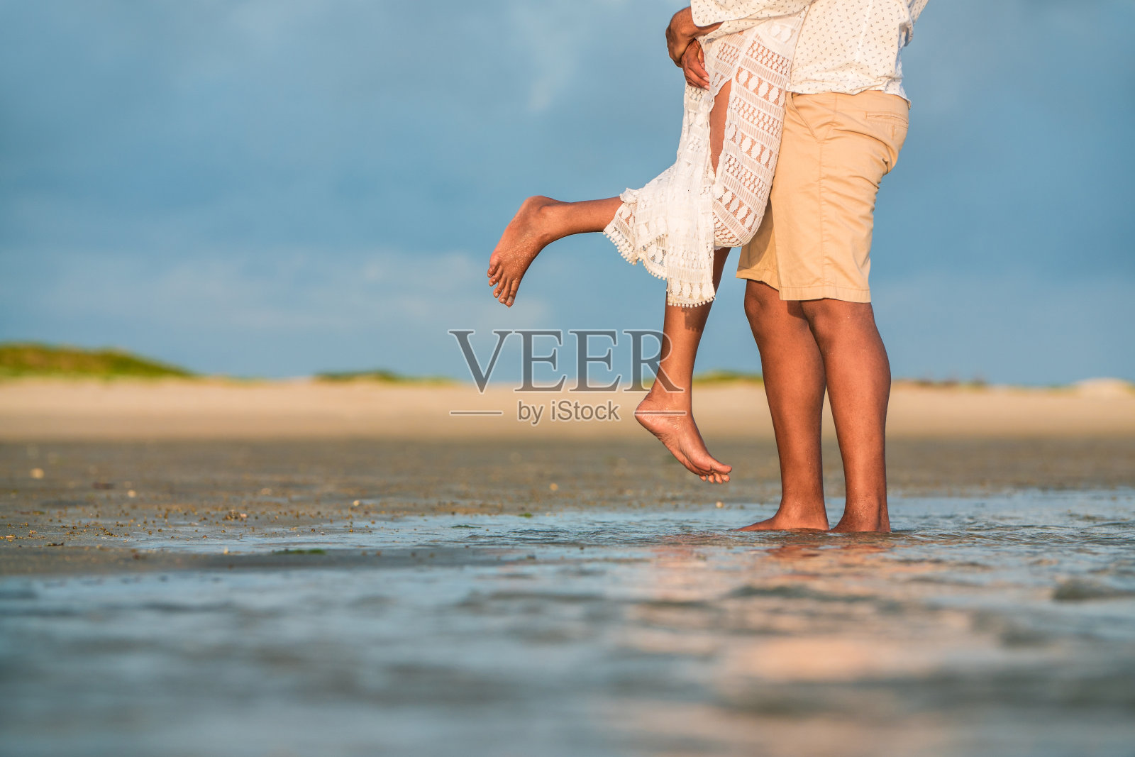 一对情侣在热带海滩上拥抱照片摄影图片