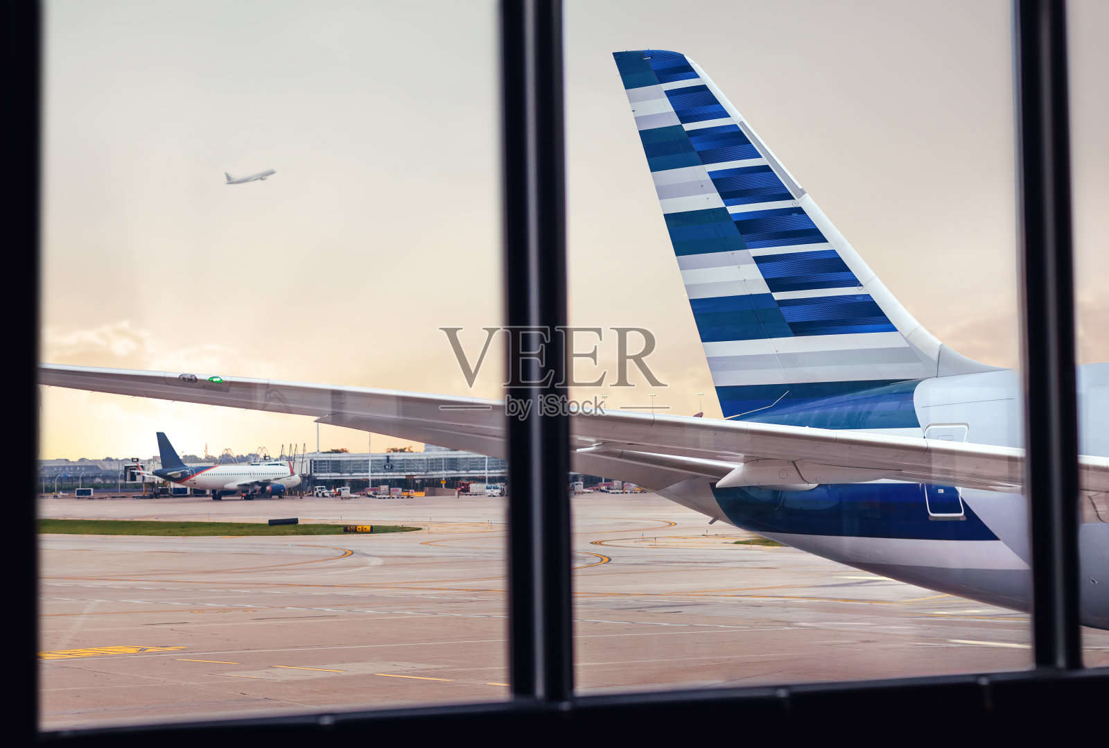 透过机场窗口观察飞机机身尾部照片摄影图片