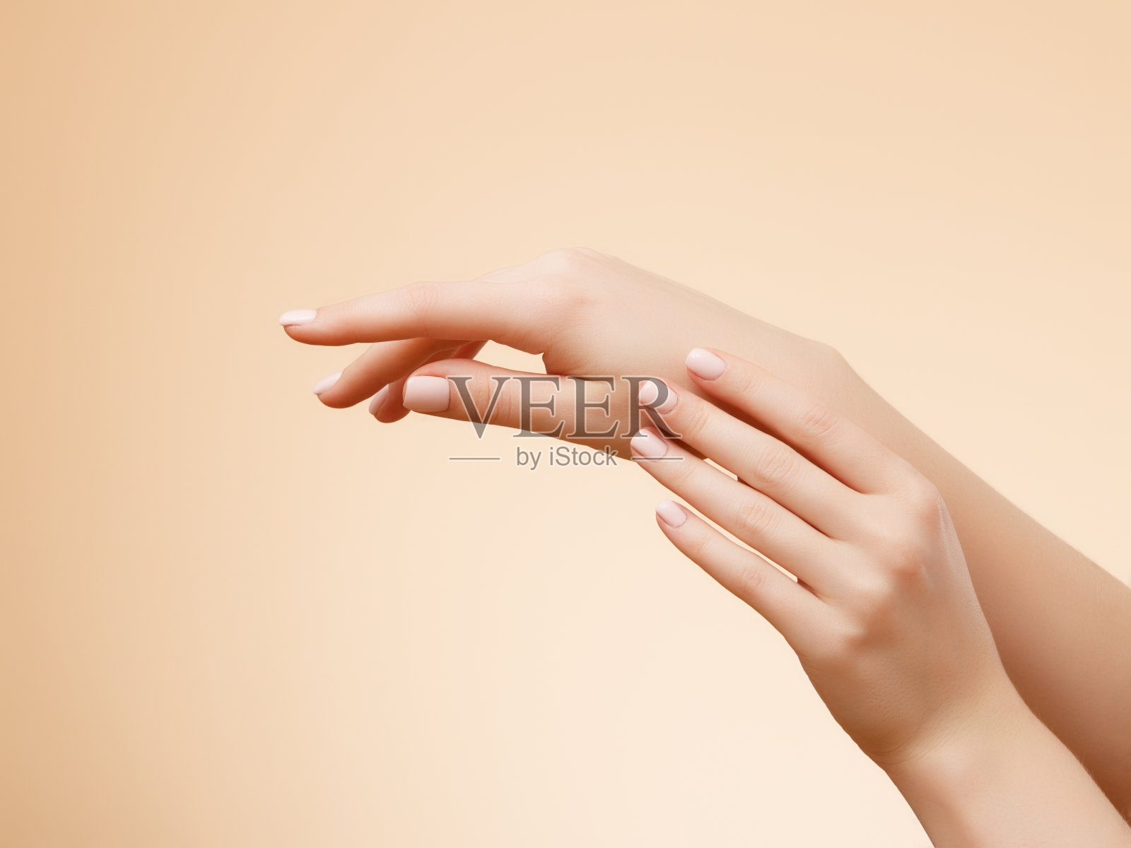 近距离的图像美丽的女人的手与浅粉红色的指甲。手部皮肤护理，修甲美容。优雅优雅的手，纤细优雅的手指照片摄影图片