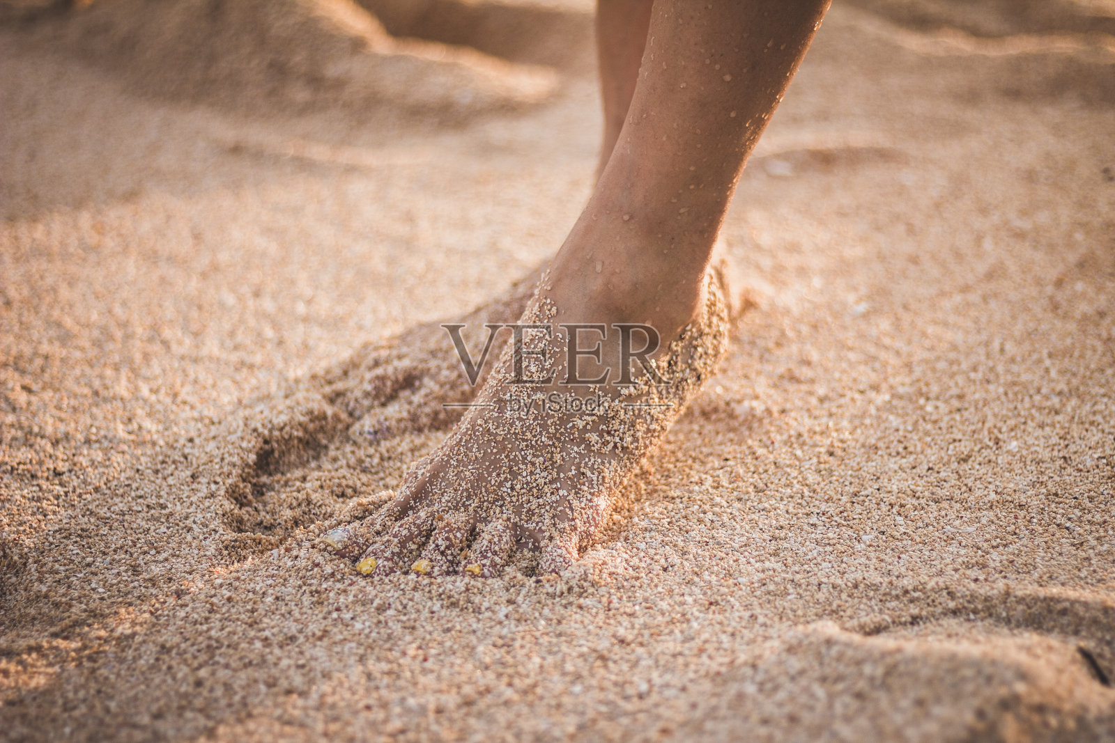 双脚被沙子覆盖照片摄影图片