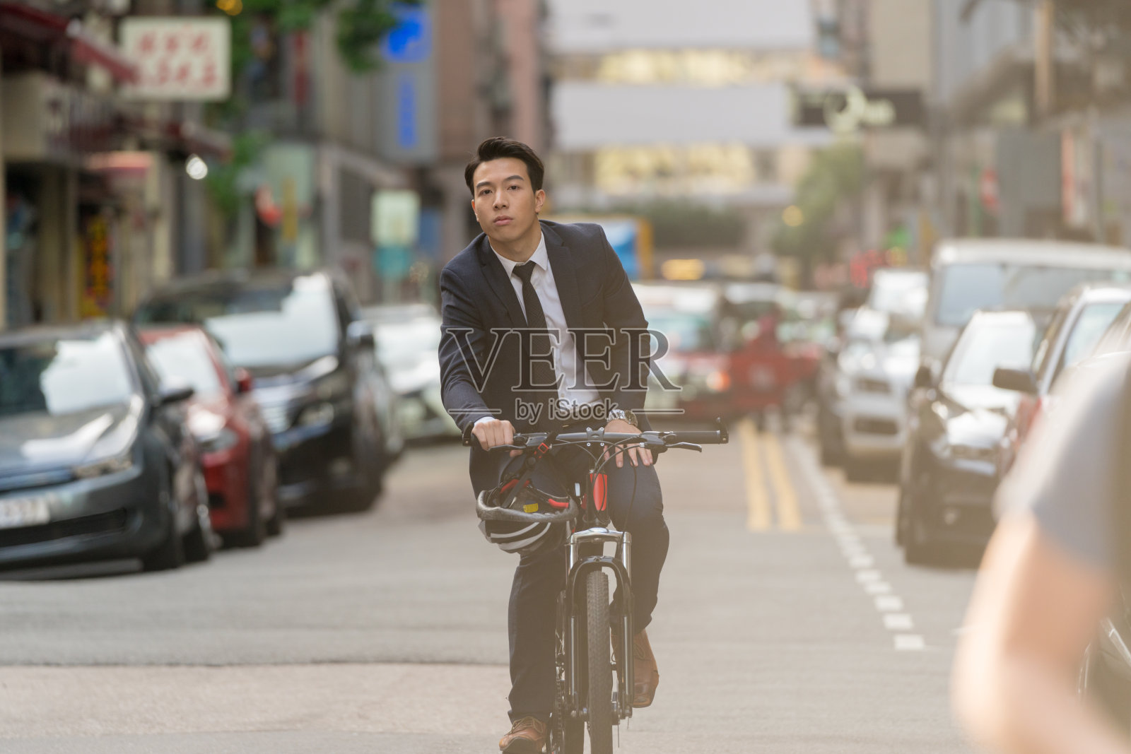 商人骑着自行车穿过城市照片摄影图片
