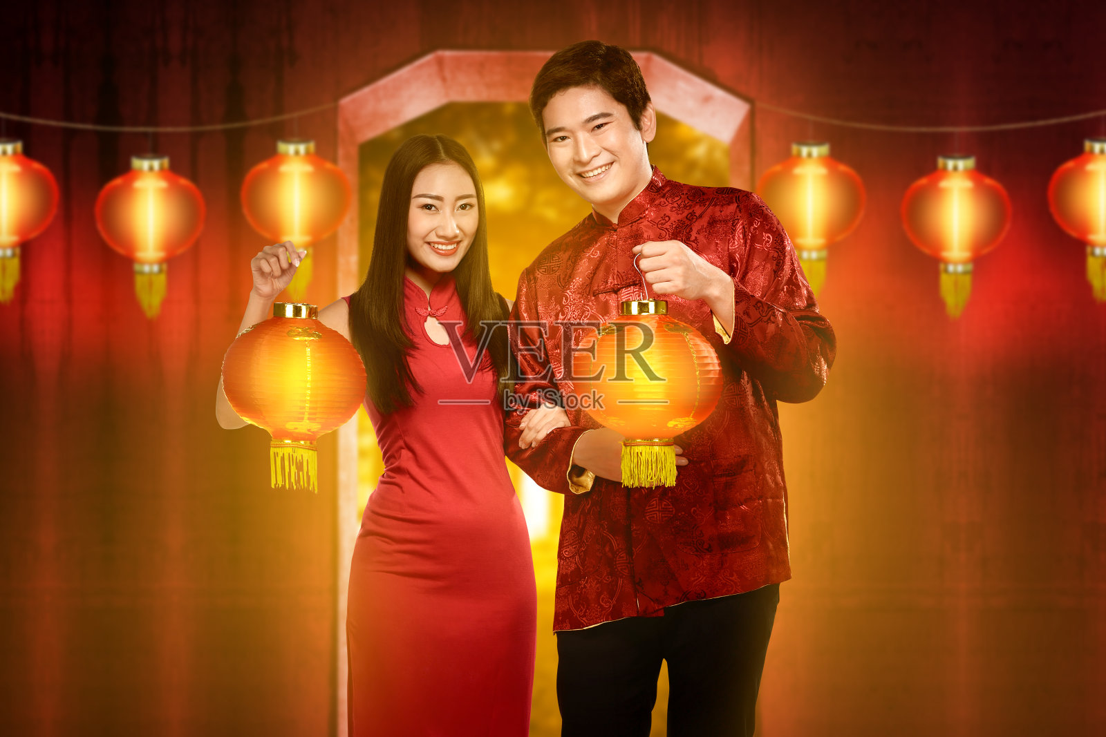 身着旗袍、手捧红灯笼的中国夫妇微笑着照片摄影图片