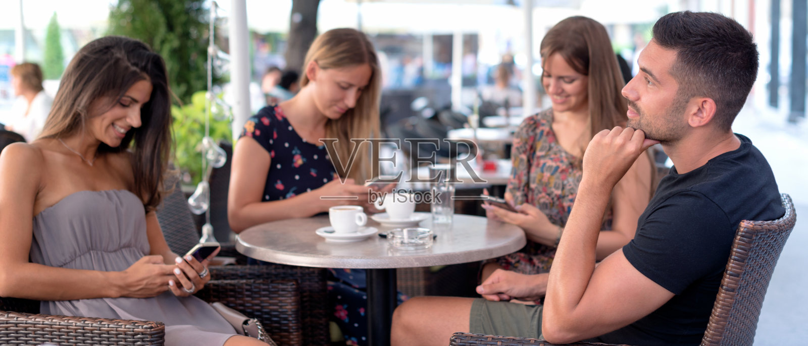 三个女人沉迷于智能手机。他们不注意他们的朋友。照片摄影图片
