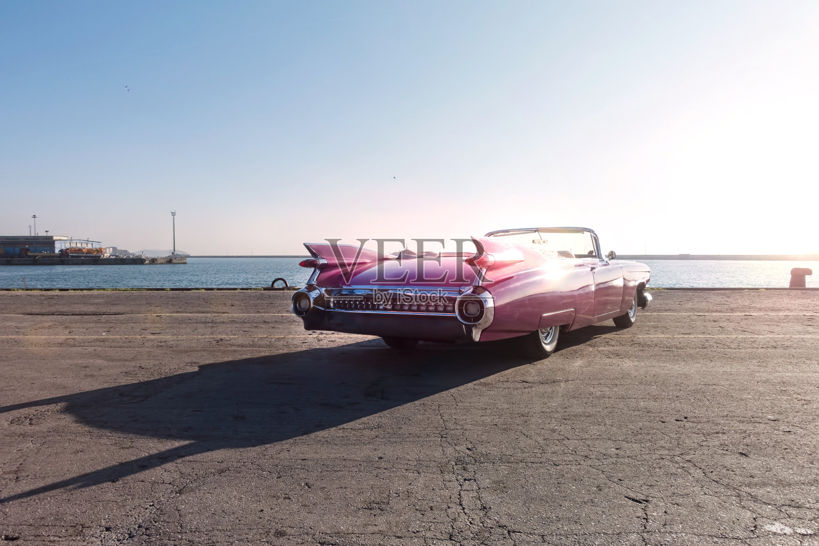 一辆美国粉色复古敞篷车停在海边。照片摄影图片