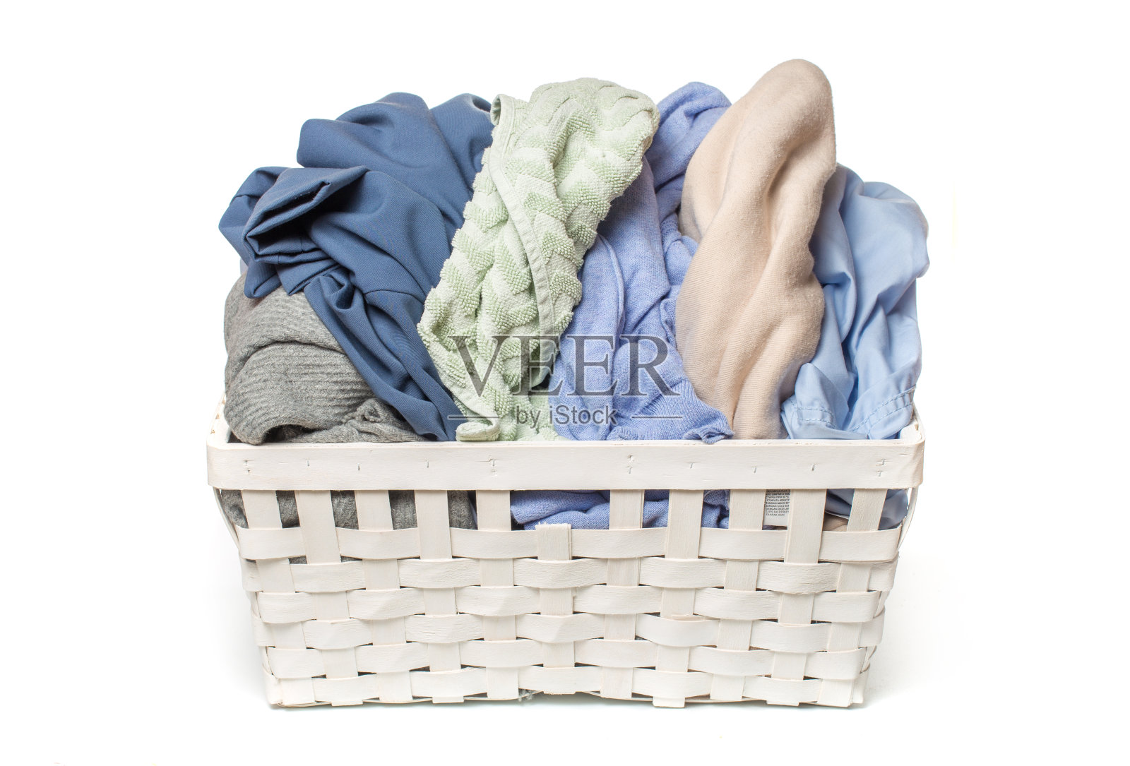 衣服放在洗衣木篮子里，以白色为背景照片摄影图片