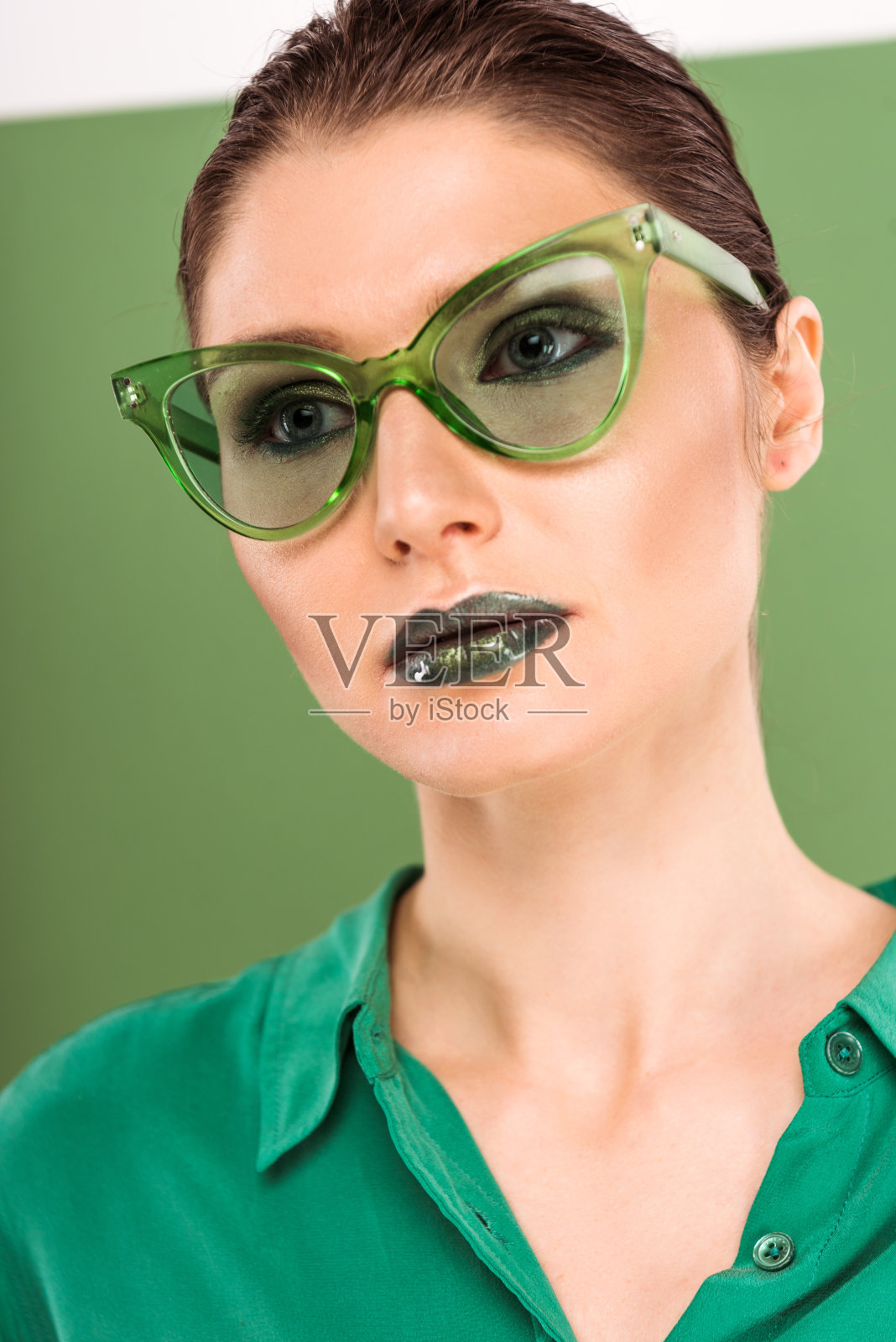 美丽的时尚女人的肖像太阳镜与海绿色的背景照片摄影图片