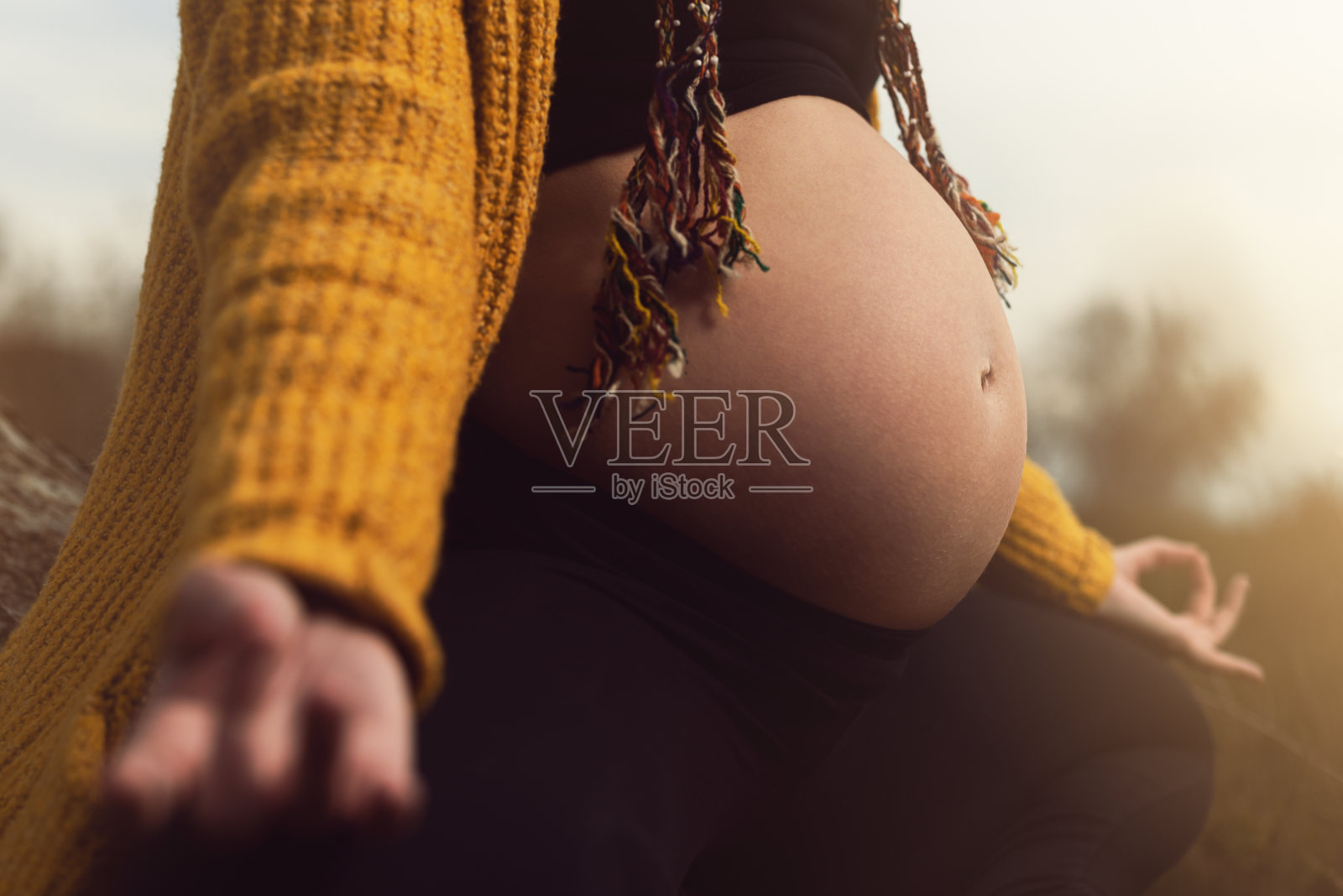 怀孕的年轻女子肖像在瑜伽莲花的位置照片摄影图片