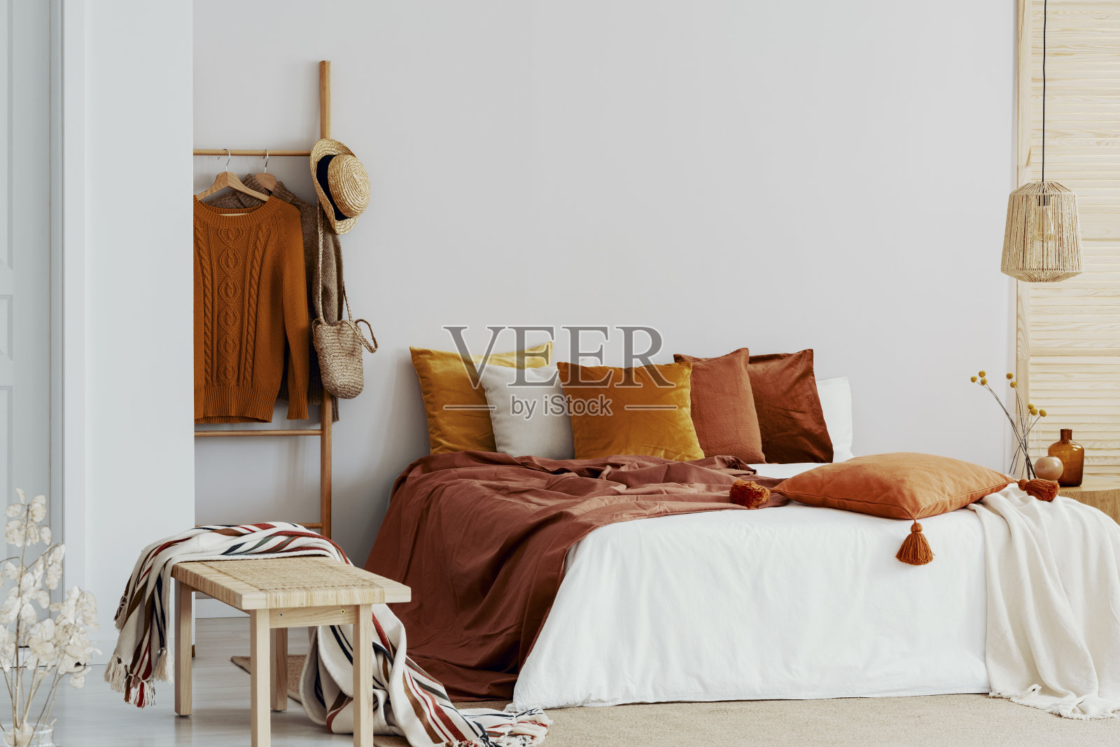 卧室有特大号的床和棕色和橙色的枕头照片摄影图片