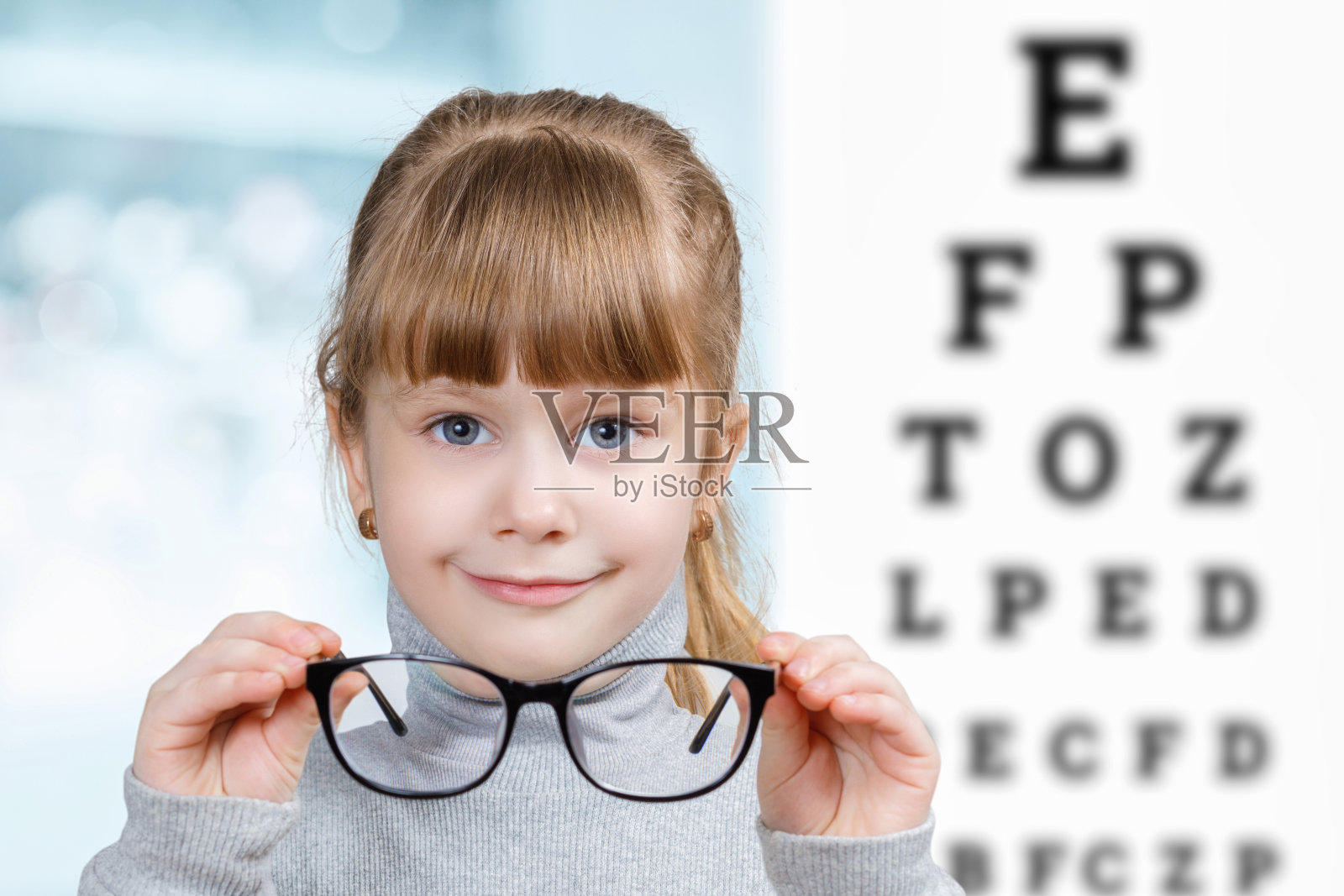 在眼科诊断中心戴眼镜的小孩。照片摄影图片