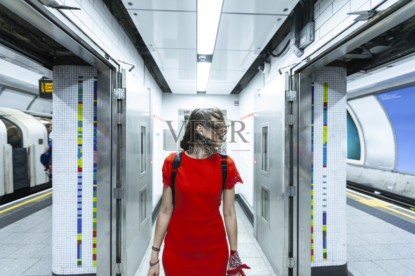 穿红色衣服的女人在地铁站行走照片摄影图片