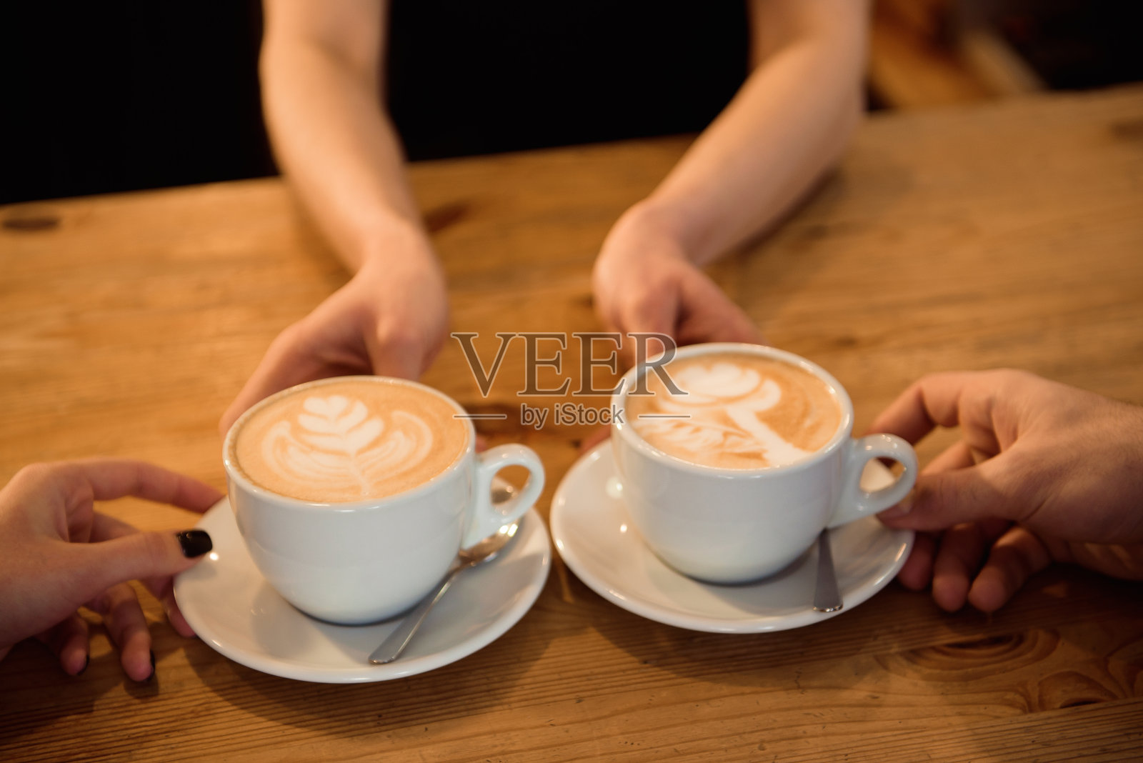 友好的调酒师在现代咖啡店的内部为顾客提供意式浓缩咖啡。照片摄影图片