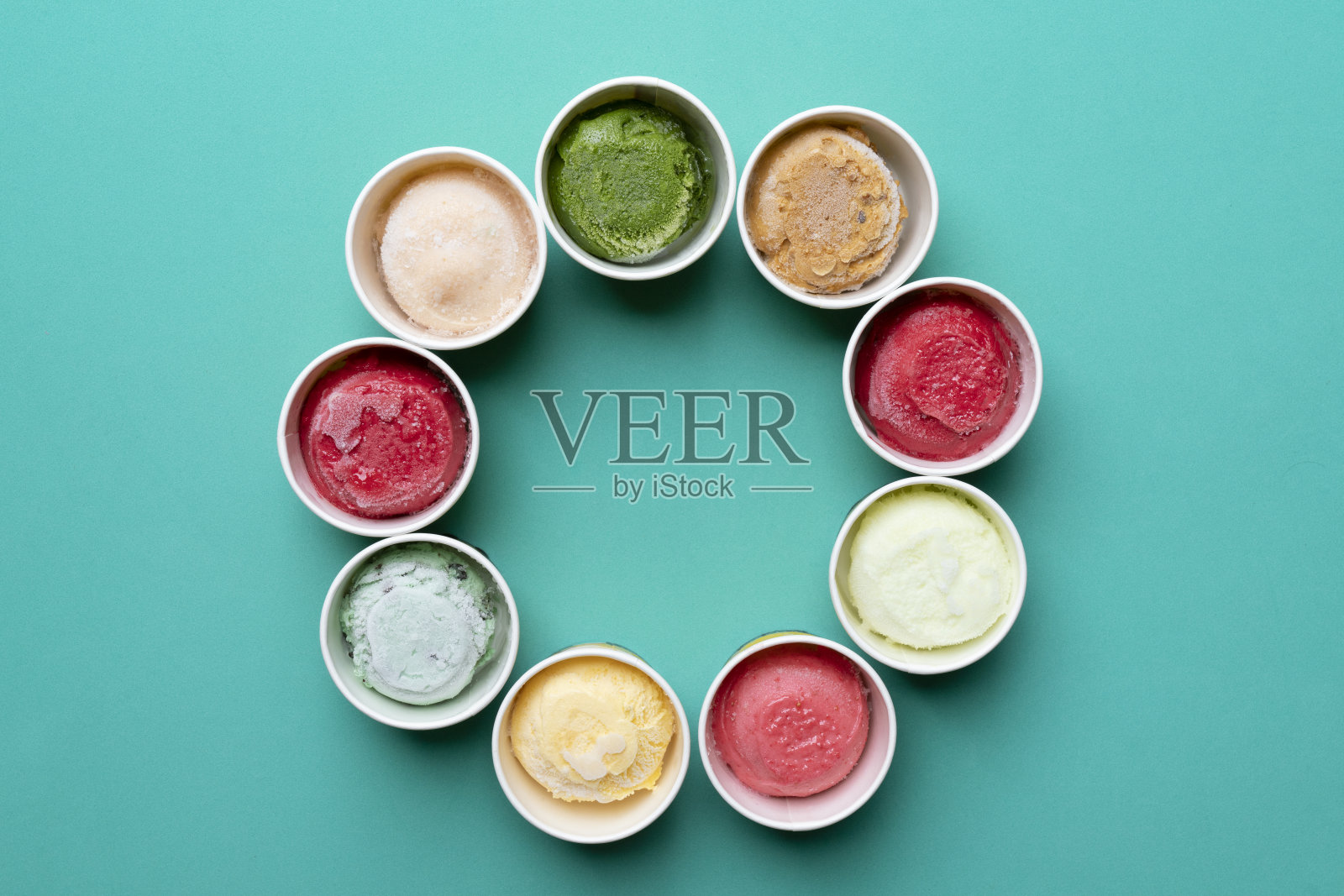 冰淇淋口味在杯子和顶部的绿色背景，甜和甜点的概念照片摄影图片