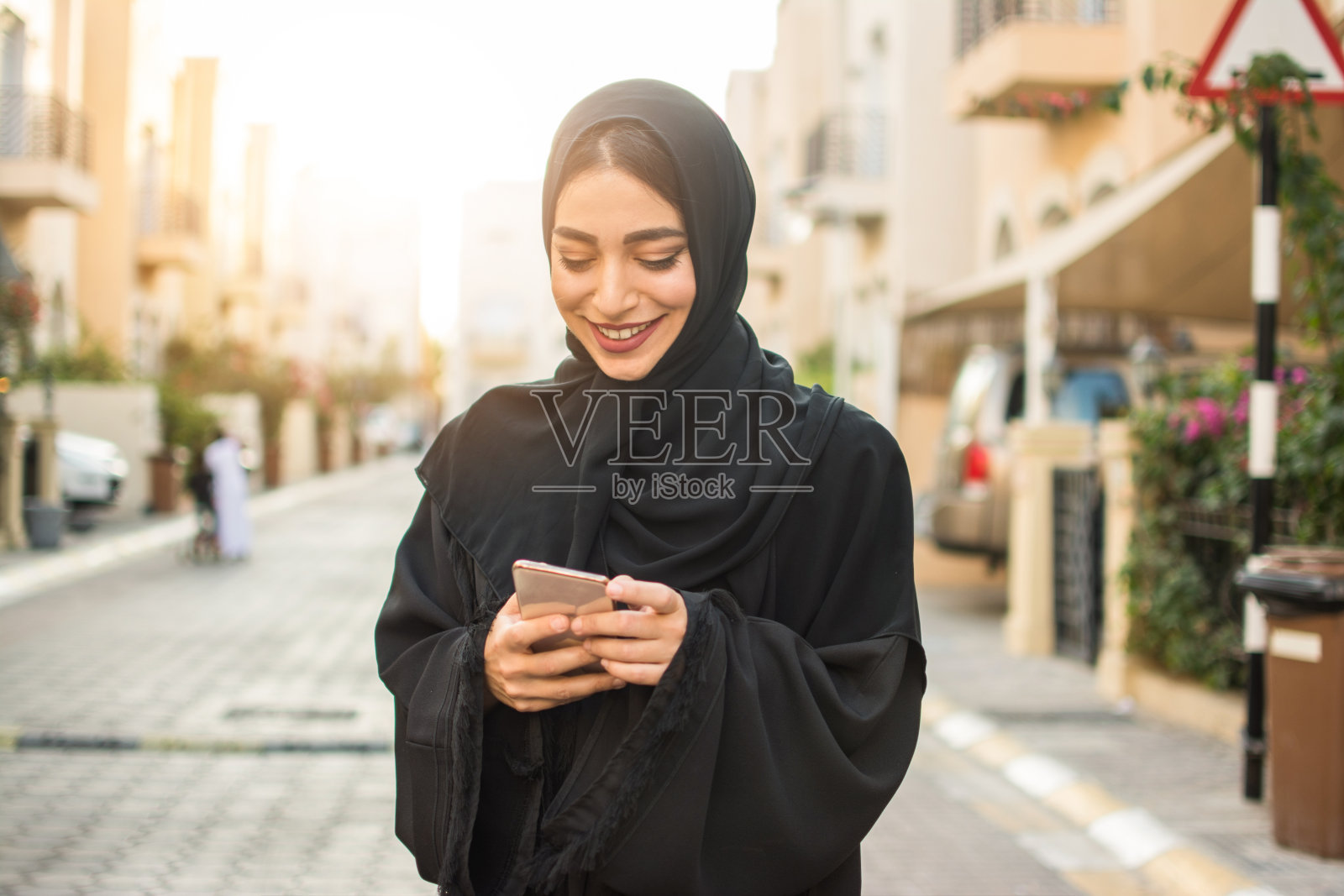 一个年轻的阿拉伯妇女在街上使用手机的肖像照片摄影图片