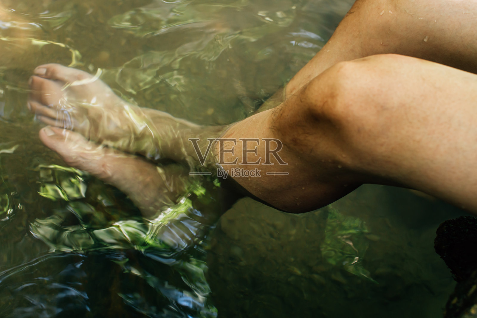 特写人类的腿浸泡在自然界的温泉里照片摄影图片