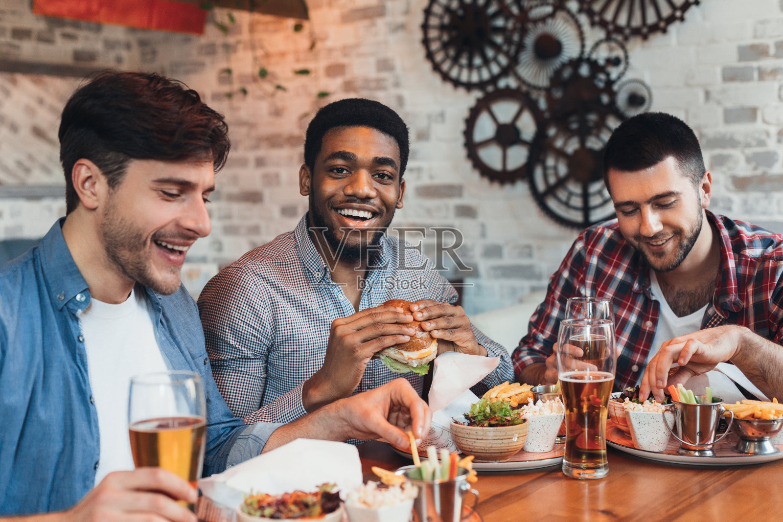 三个男人在酒吧享受汉堡和啤酒照片摄影图片