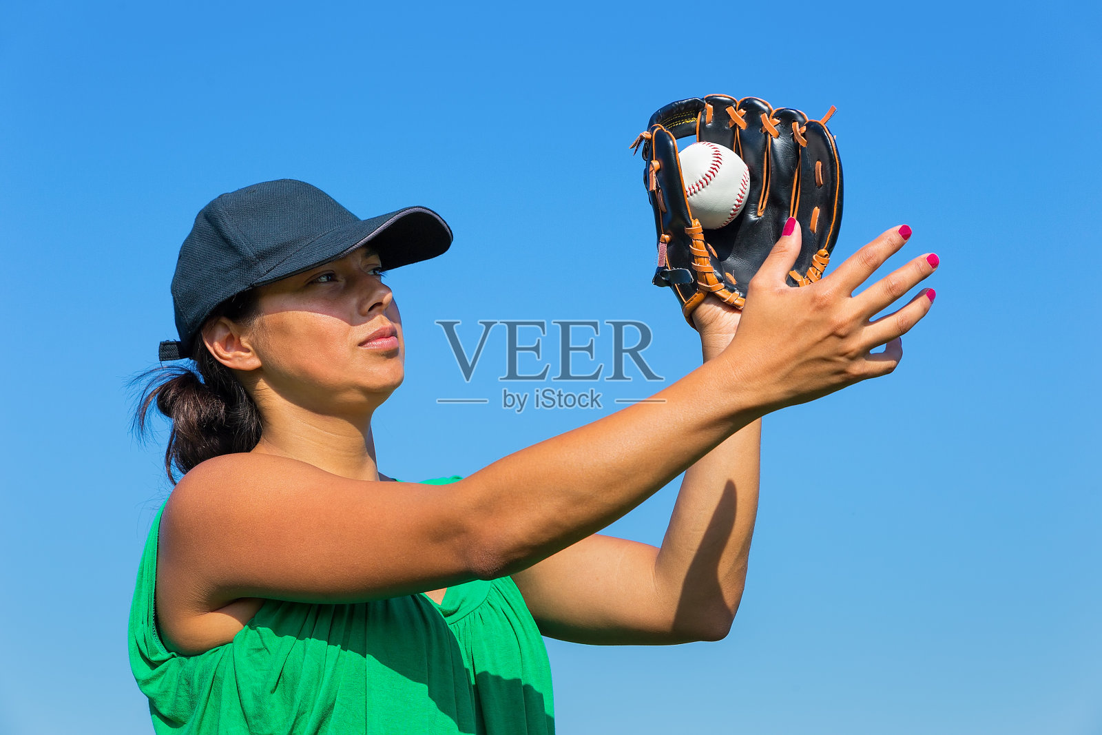 戴手套和帽子的女人接棒球照片摄影图片