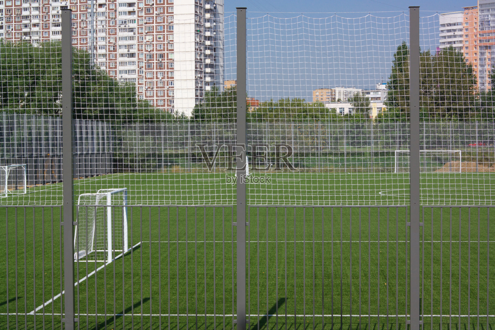 在阳光明媚的一天，足球场附近的栅栏照片摄影图片