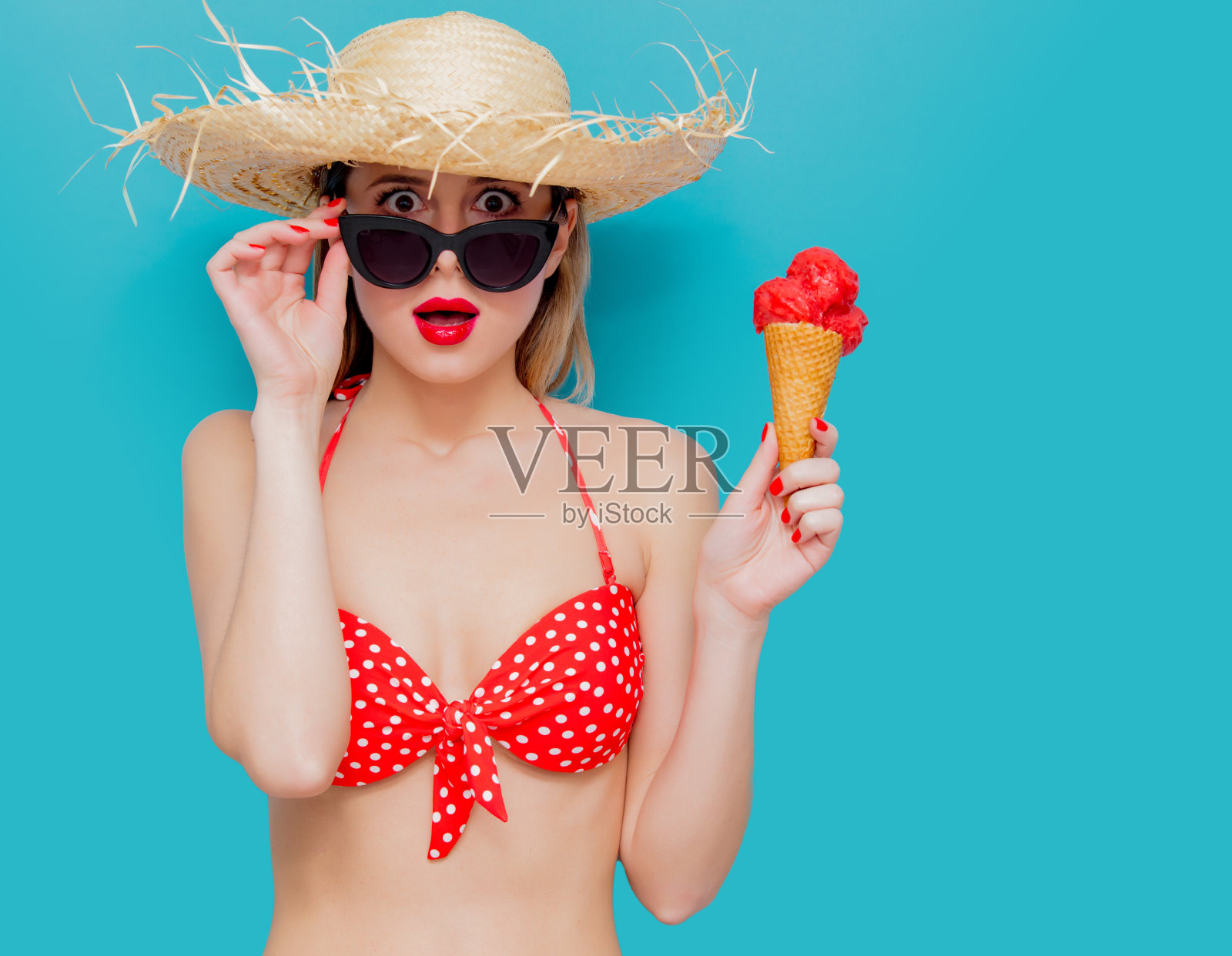 年轻女子穿着红色比基尼和草帽和冰淇淋照片摄影图片