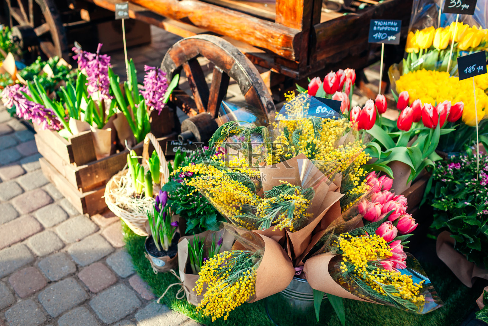 花卉市场。春天的鲜花在盒子和桶准备出售。风信子，含羞草和郁金香。母亲节礼物照片摄影图片