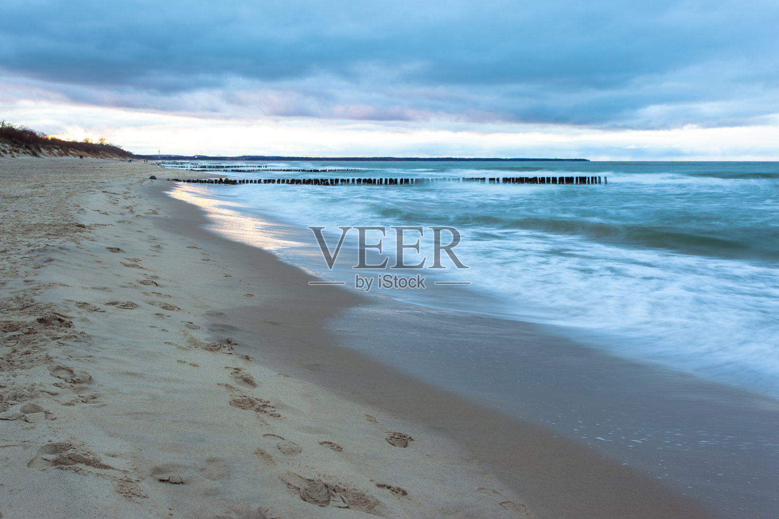 有防波堤的沙滩在寒冷的海边在蓝色的黄昏在阴天长时间暴露照片摄影图片