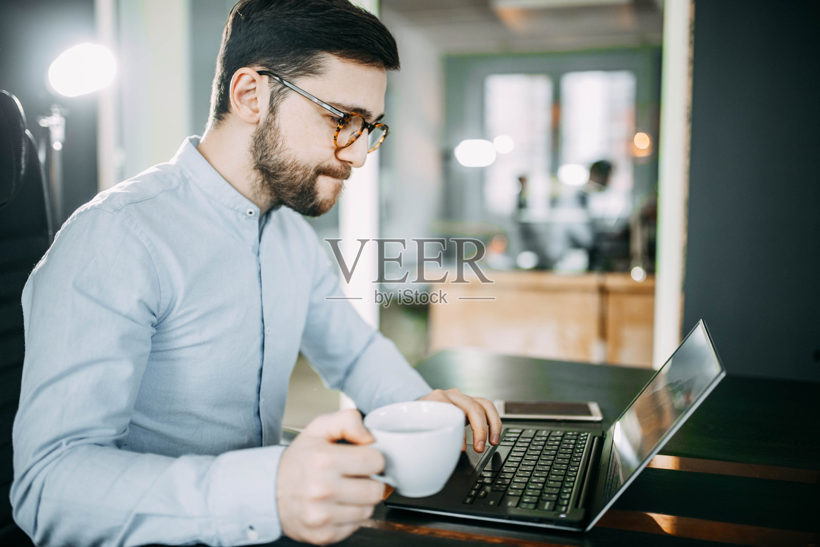商务办公室的工作人员戴着眼镜，留着胡子在早上喝咖啡。职业公司的概念照片摄影图片