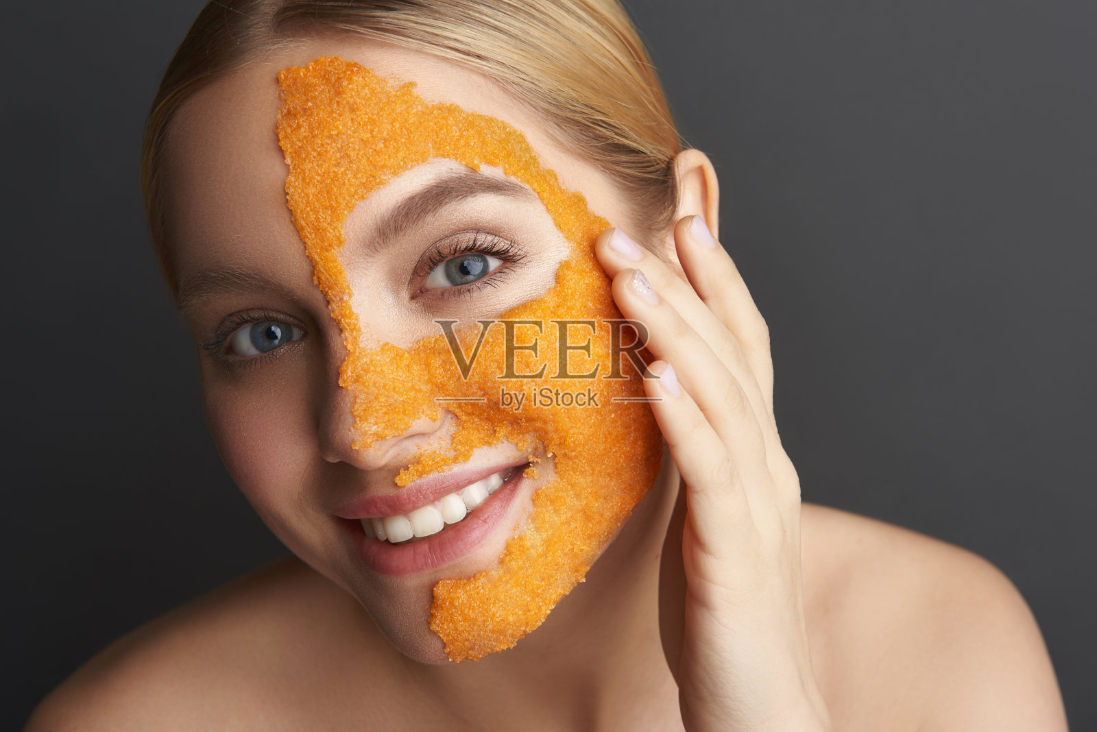 肖像微笑的女人用橘皮面膜在她的皮肤照片摄影图片