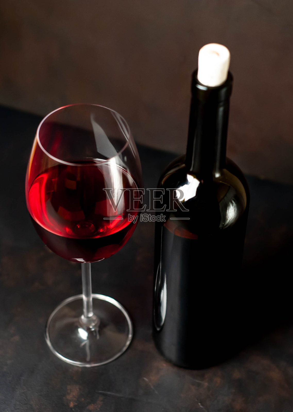 石头背景上的红酒杯和葡萄酒酒瓶。从上面的观点照片摄影图片