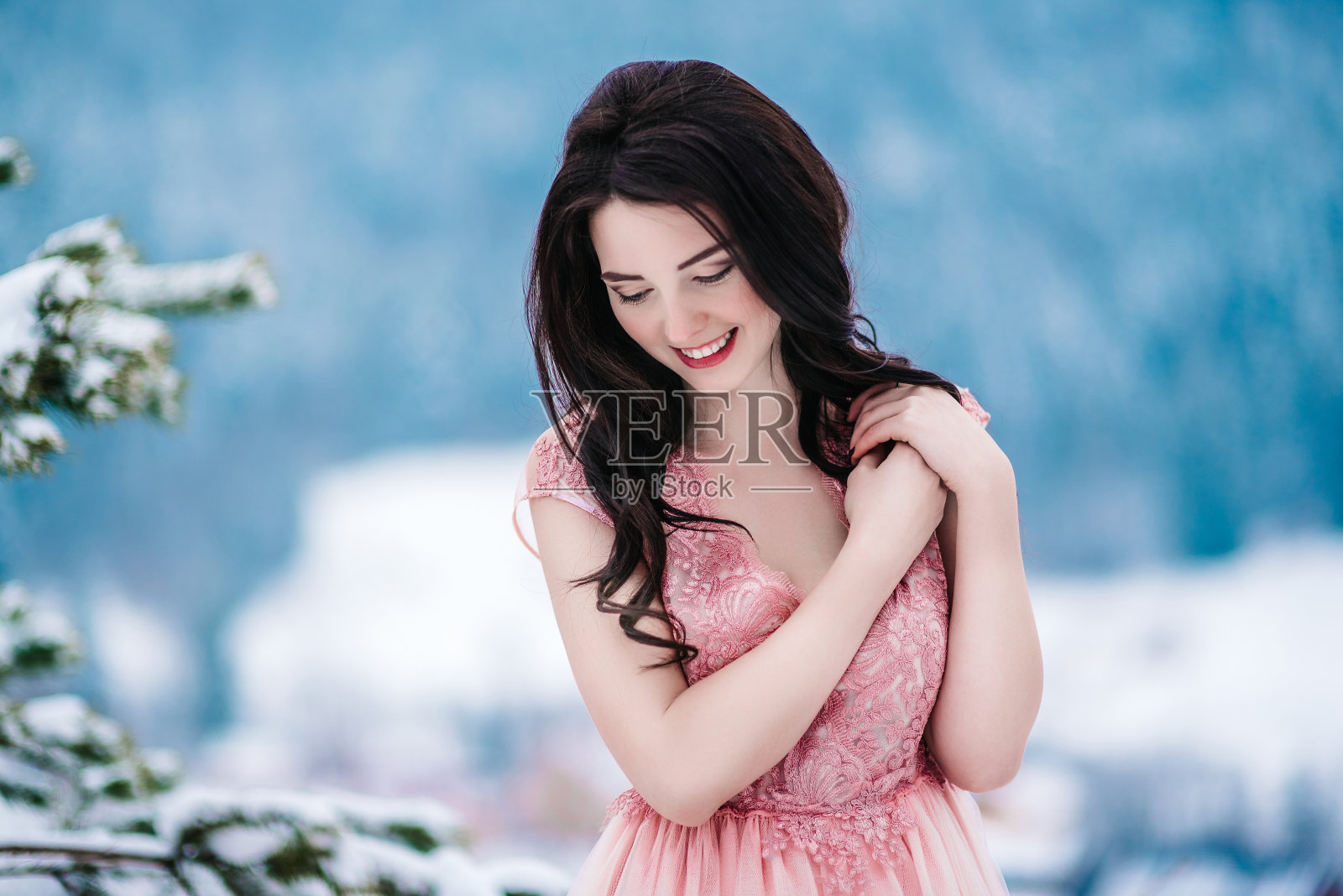 栗色头发的新娘，冬天群山的蓝色背景照片摄影图片