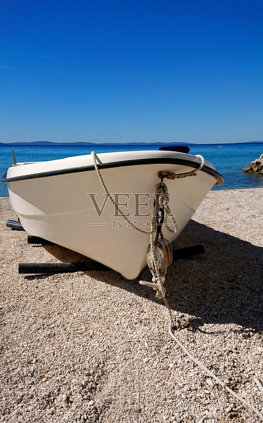 近距离观察礁石岸边的渔船。在克罗地亚斯普利特海滩的航海和海洋背景。照片摄影图片