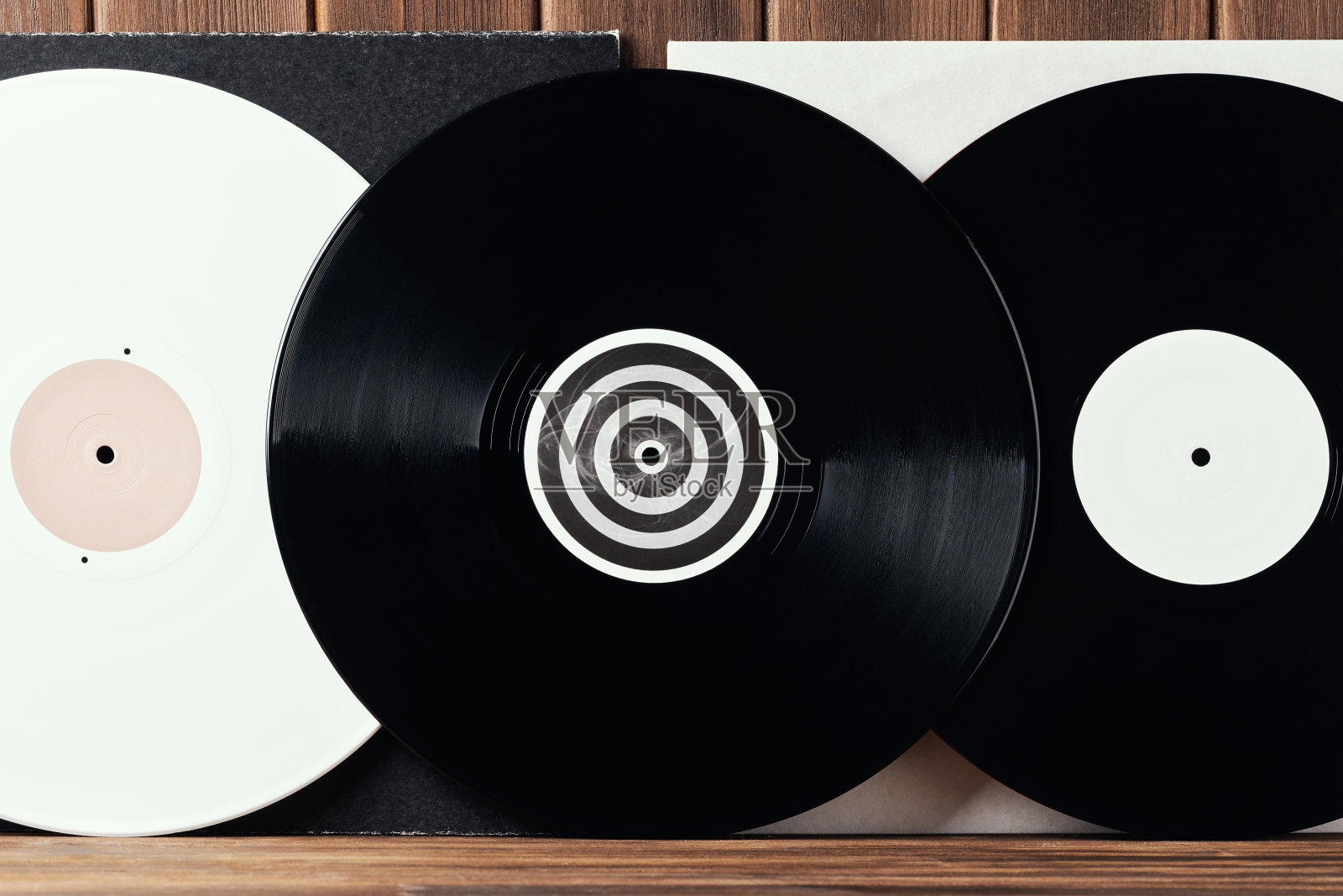 明亮的白色和黑色的黑胶唱片的转盘上灰色和白色的封面上一个旧的木板背景。贺卡框架与地方为您的文字设计。前视图特写照片摄影图片