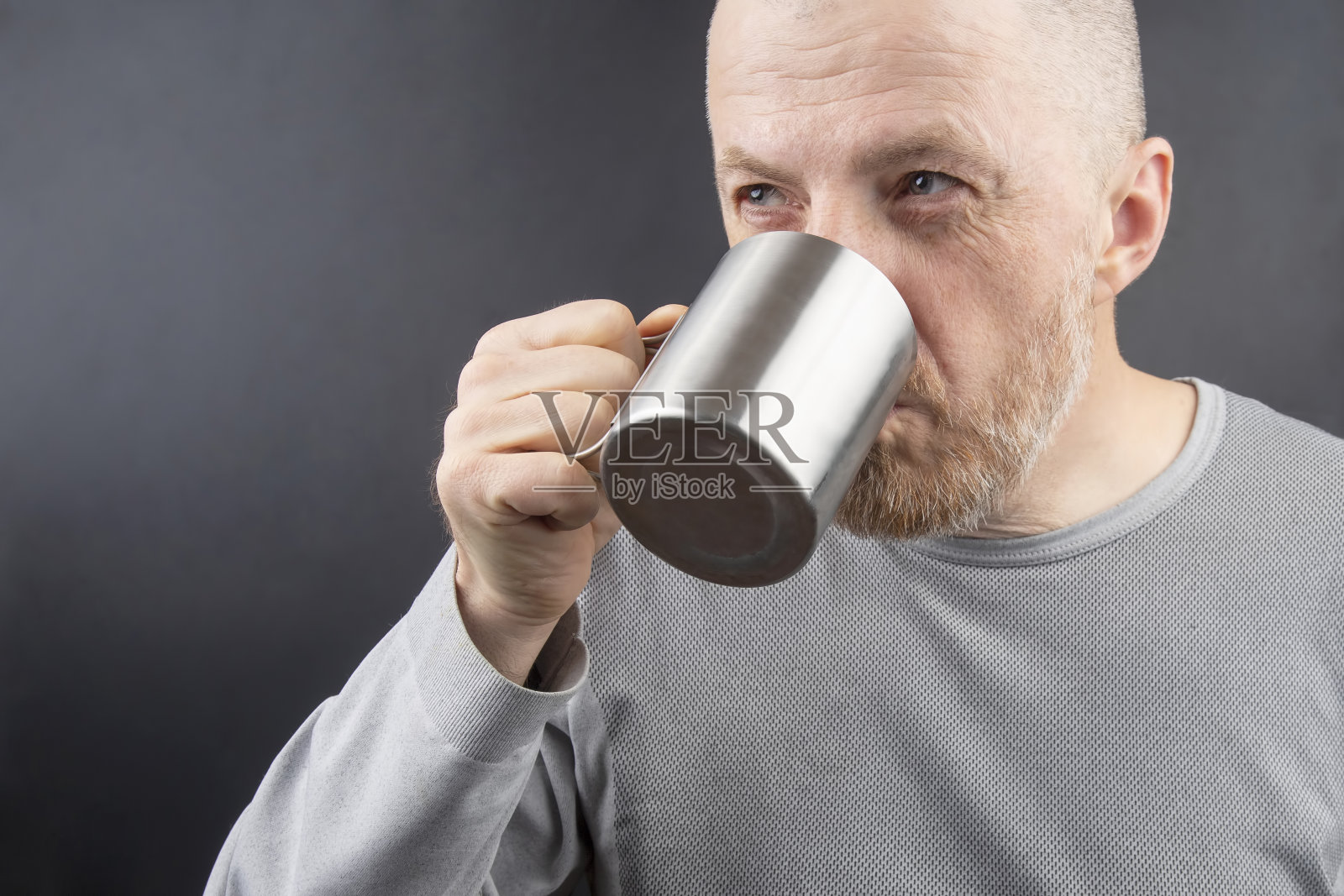 用金属杯子喝茶的大胡子男人照片摄影图片