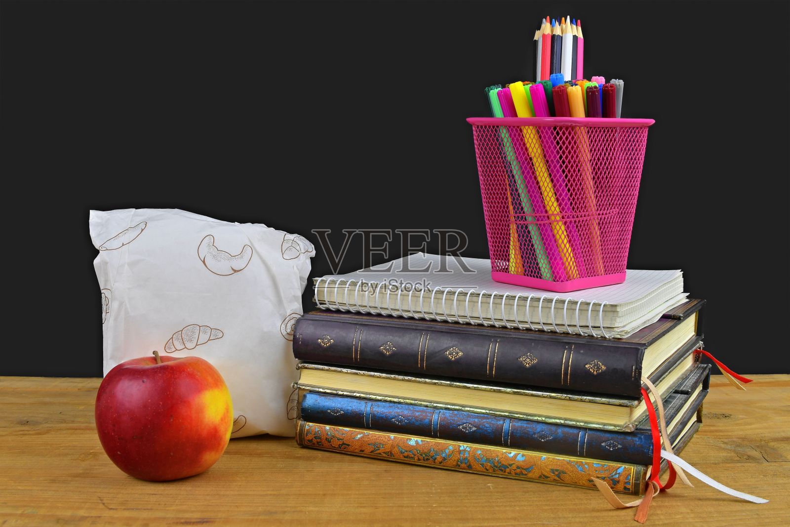 学校午餐休息的概念与苹果和学校用品在木桌上，选择性的重点。书，马克笔和彩色铅笔强调概念。学习和放松的时间到了。照片摄影图片