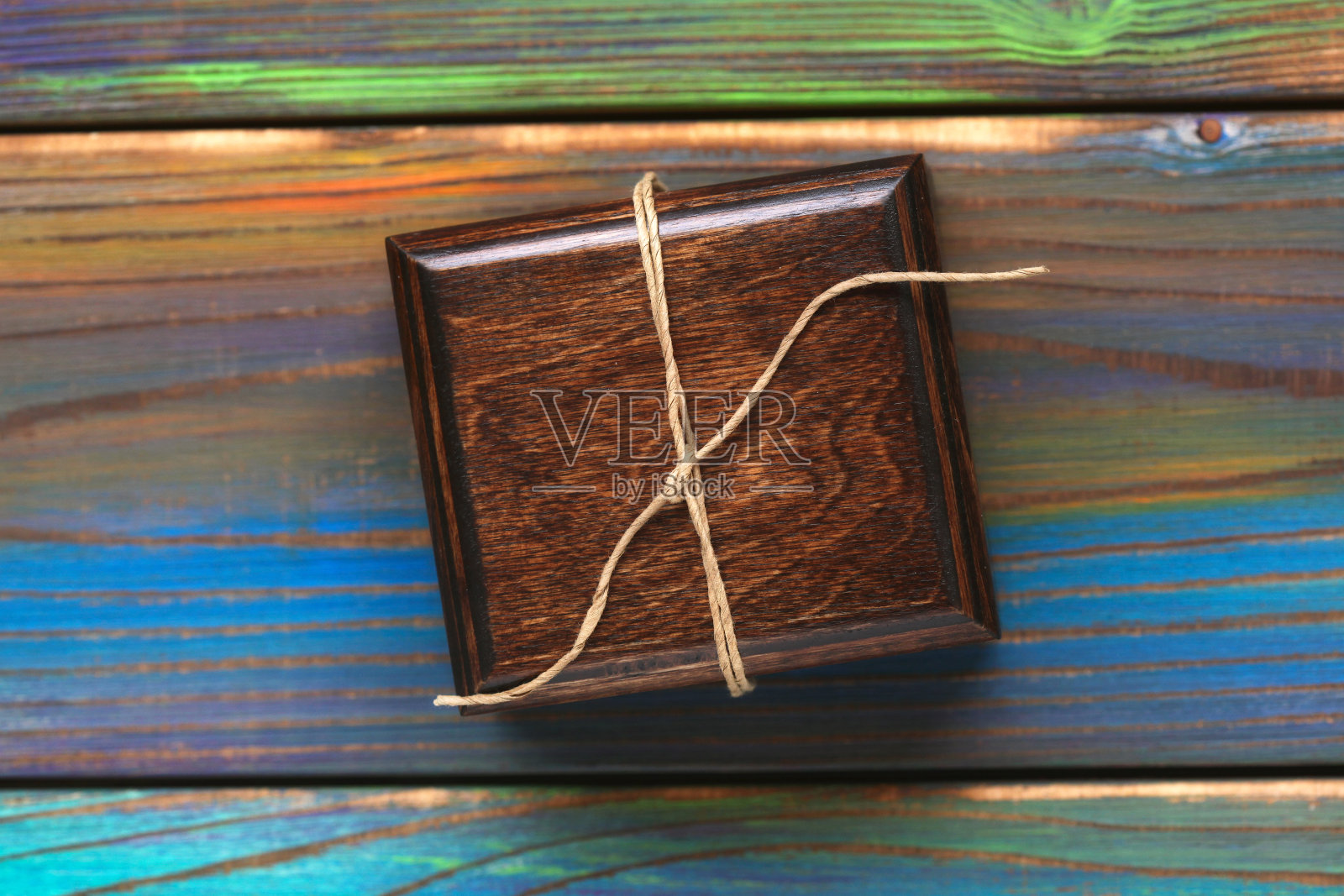 木制礼盒上的彩色纹理背景。用绳子绑着的首饰盒。俯视图，木制背景。照片摄影图片