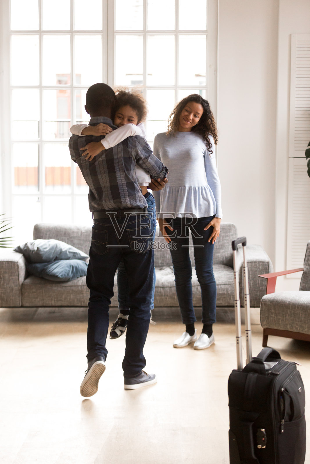快乐的黑人家庭兴奋地在家里与父亲团聚照片摄影图片